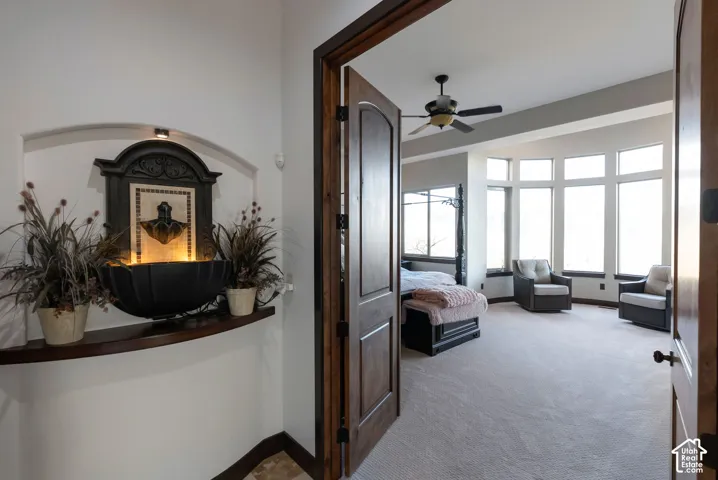 Hallway with light carpet and baseboards
