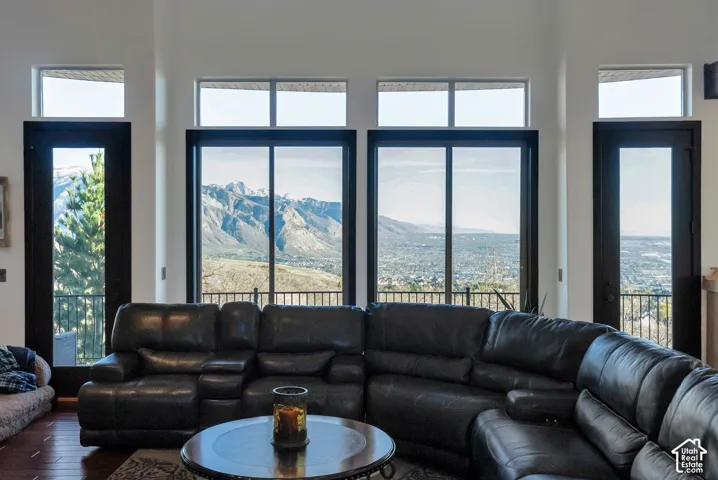 Living area featuring a mountain view, healthy amount of natural light, hardwood / wood-style floors, and a high ceiling