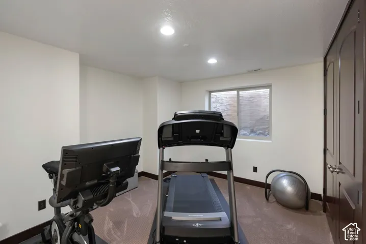 Workout area featuring baseboards and carpet flooring