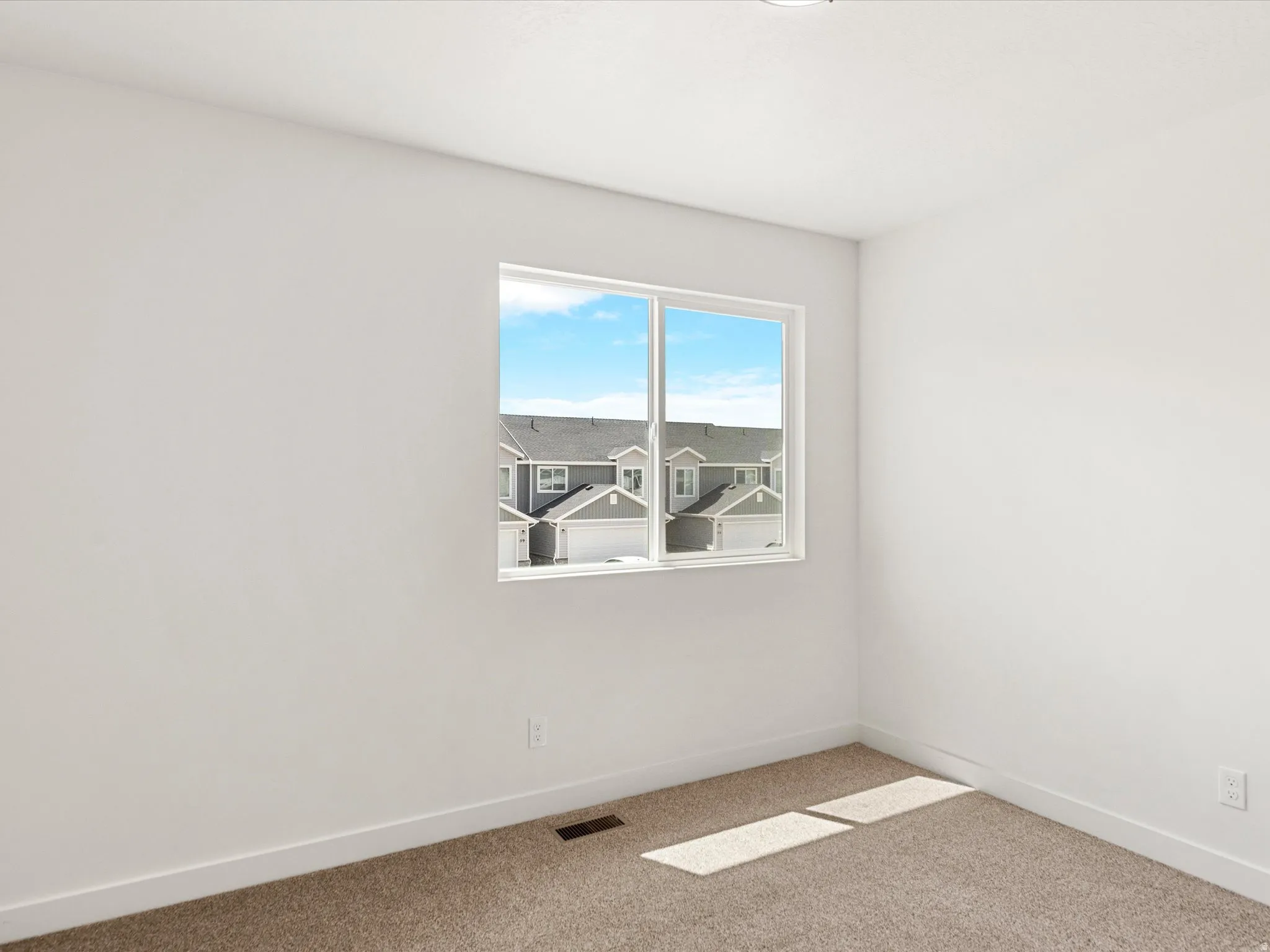 Spare room featuring baseboards and light carpet