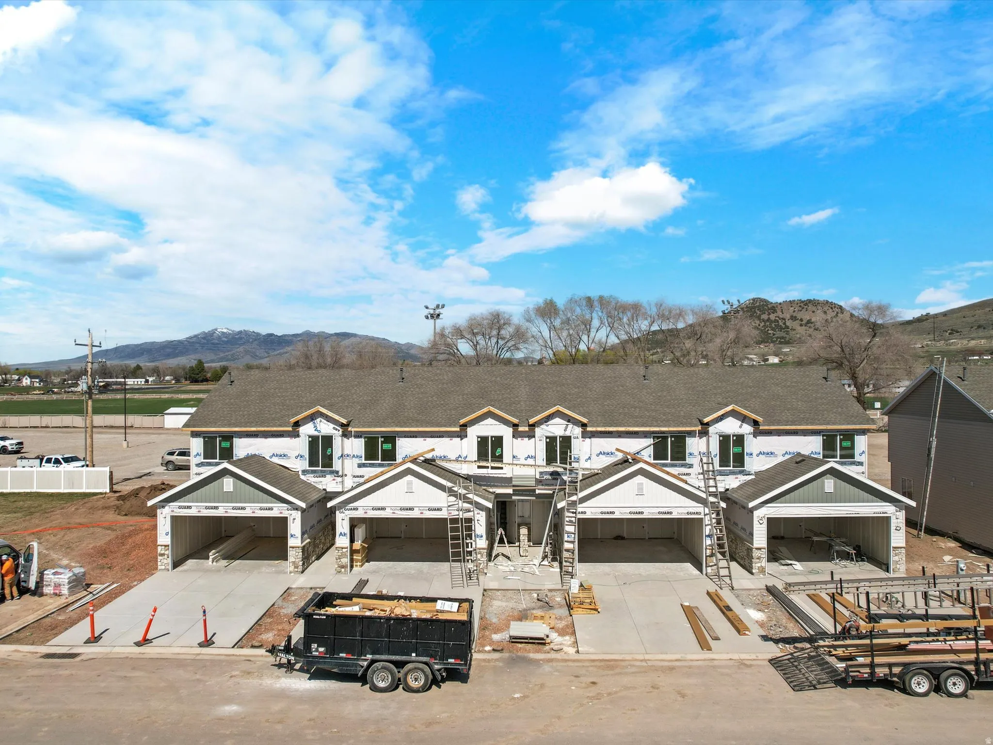 Property in mid-construction featuring stone siding, a mountain view, concrete driveway, board and batten siding, and a garage