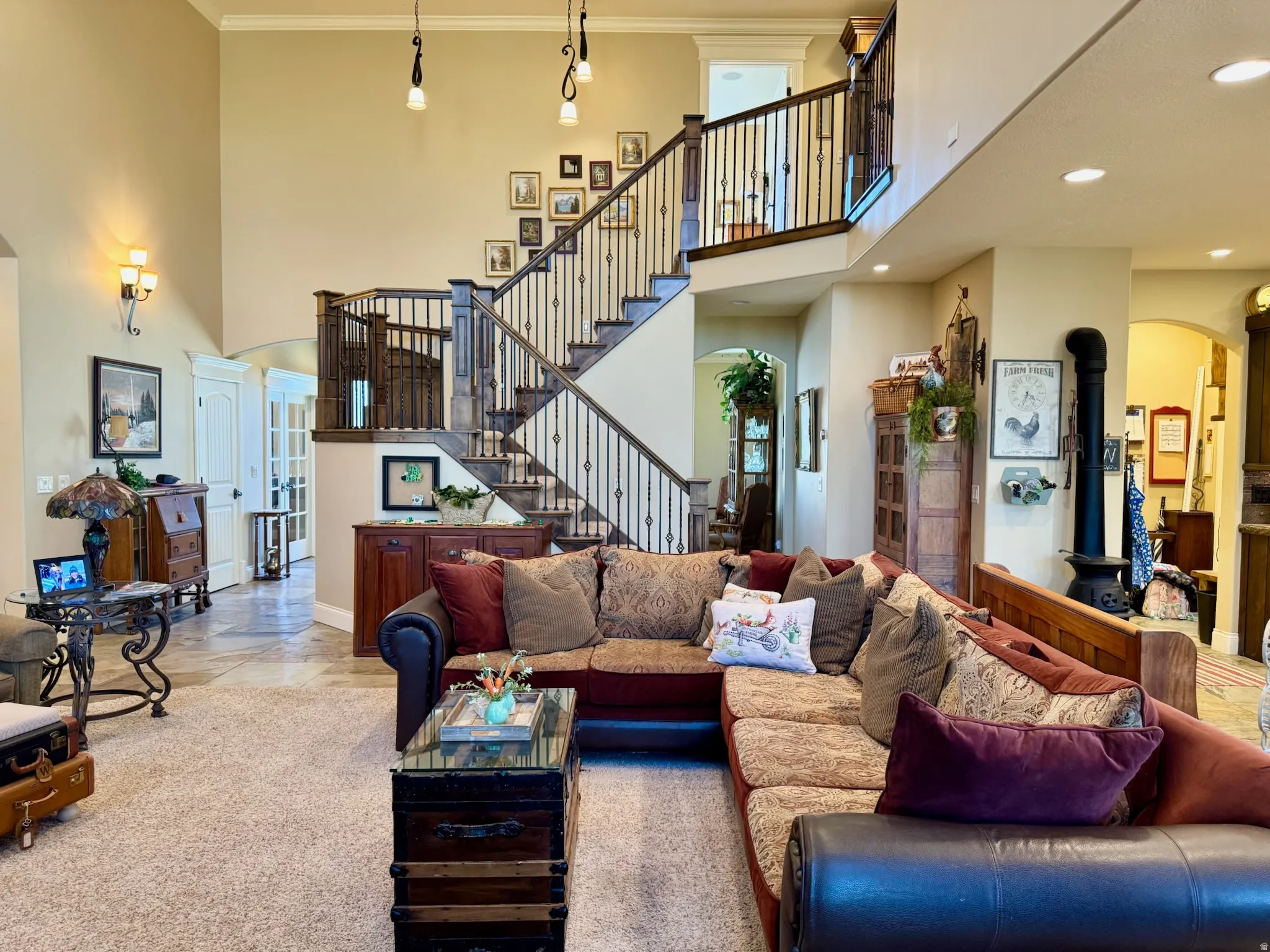 Living room with arched walkways, a high ceiling, recessed lighting, and light tile patterned flooring
