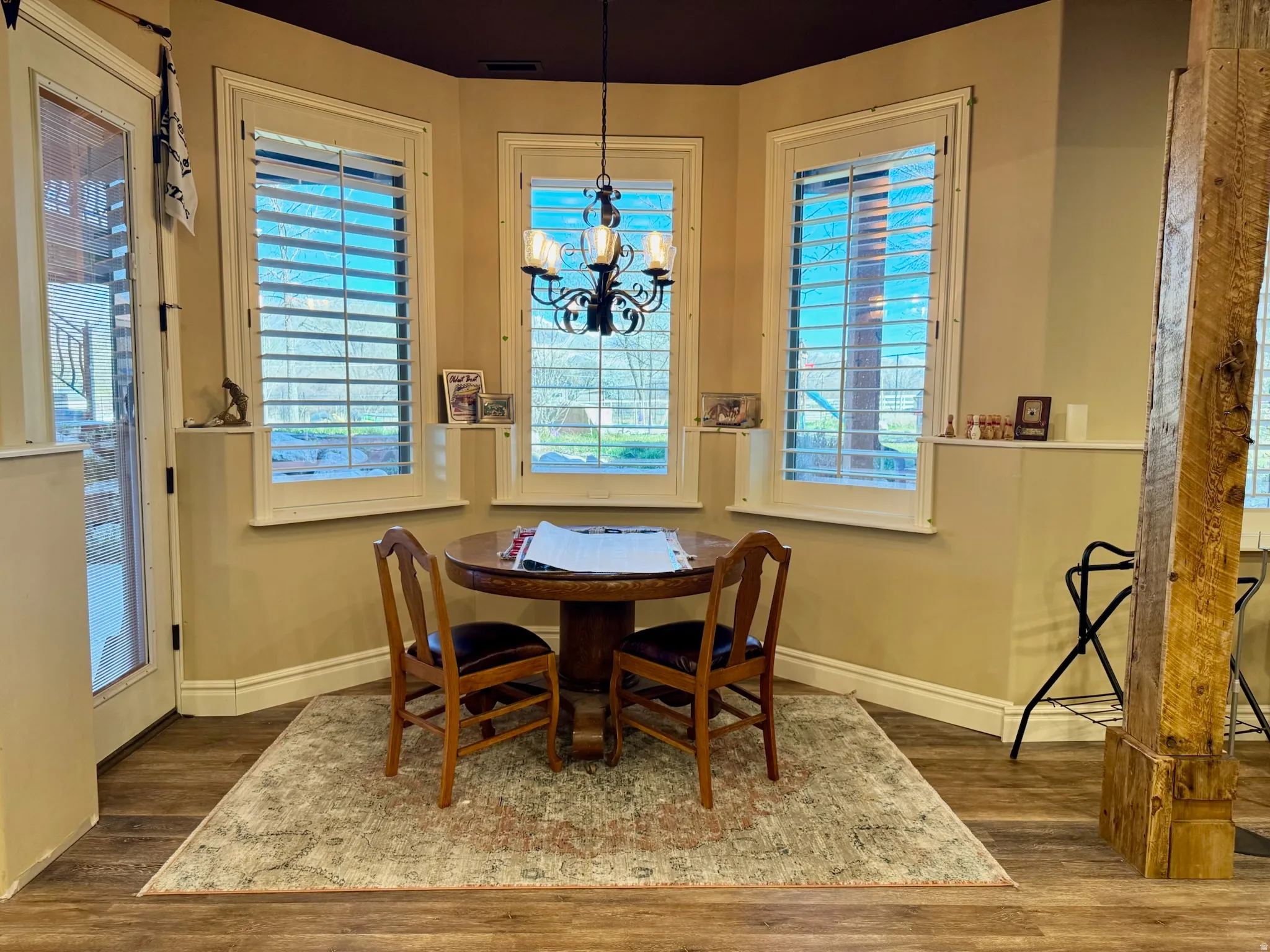 Dining space featuring suspended lighting and dark wood-style floors