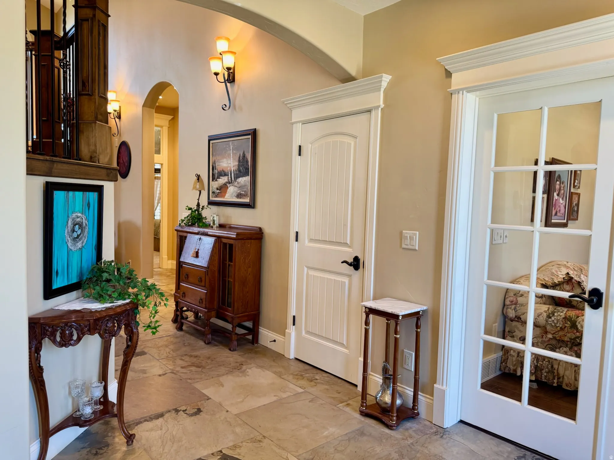 Entryway featuring arched walkways and light stone finish floors