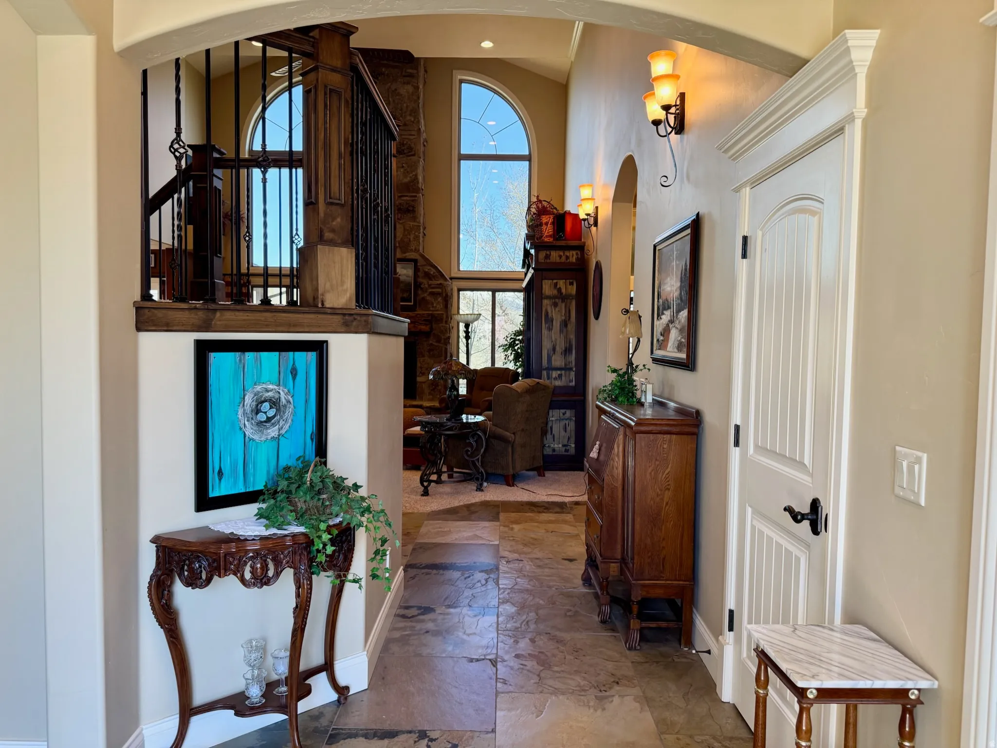 Foyer entrance featuring stone finish floors, arched walkways, and a high ceiling