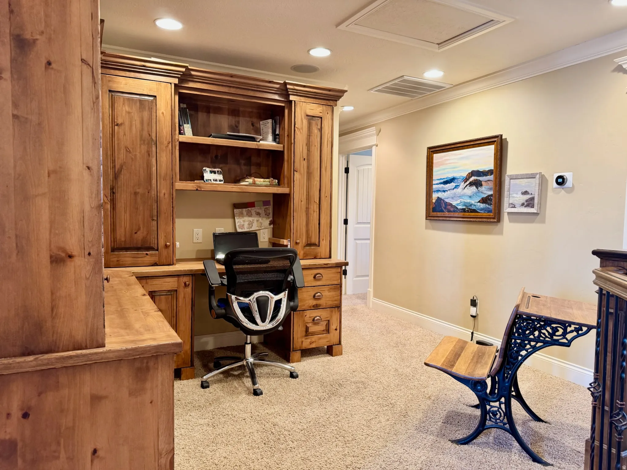 Office area featuring light colored carpet, ornamental molding, recessed lighting, and built in desk