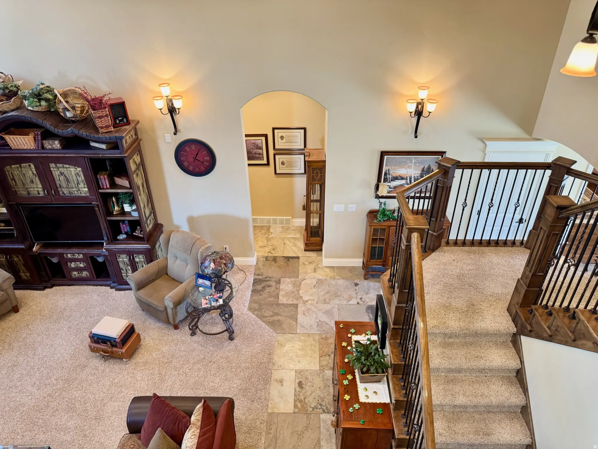 Living room featuring arched walkways and light stone finish flooring
