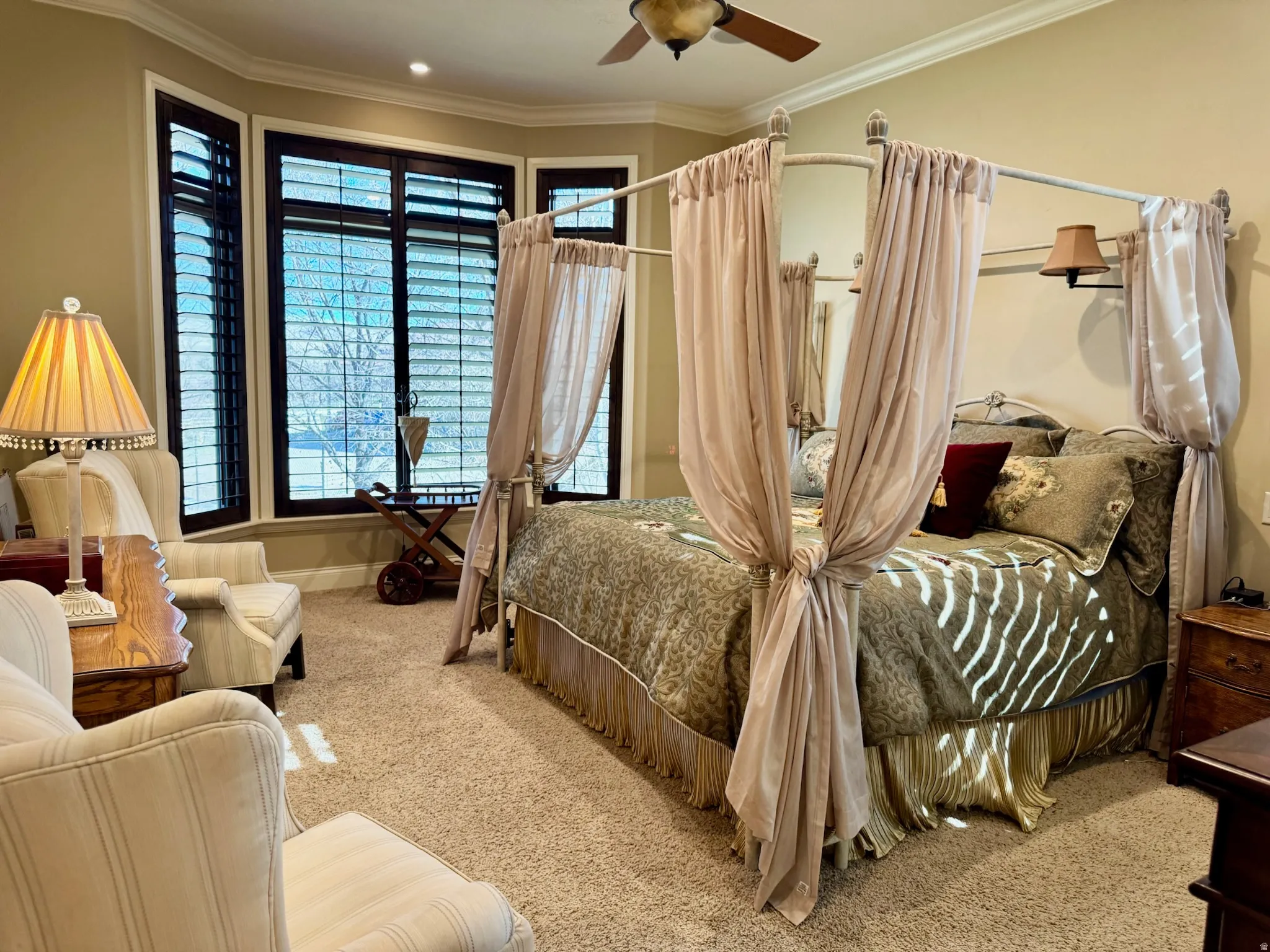 Carpeted bedroom with ornamental molding and a ceiling fan