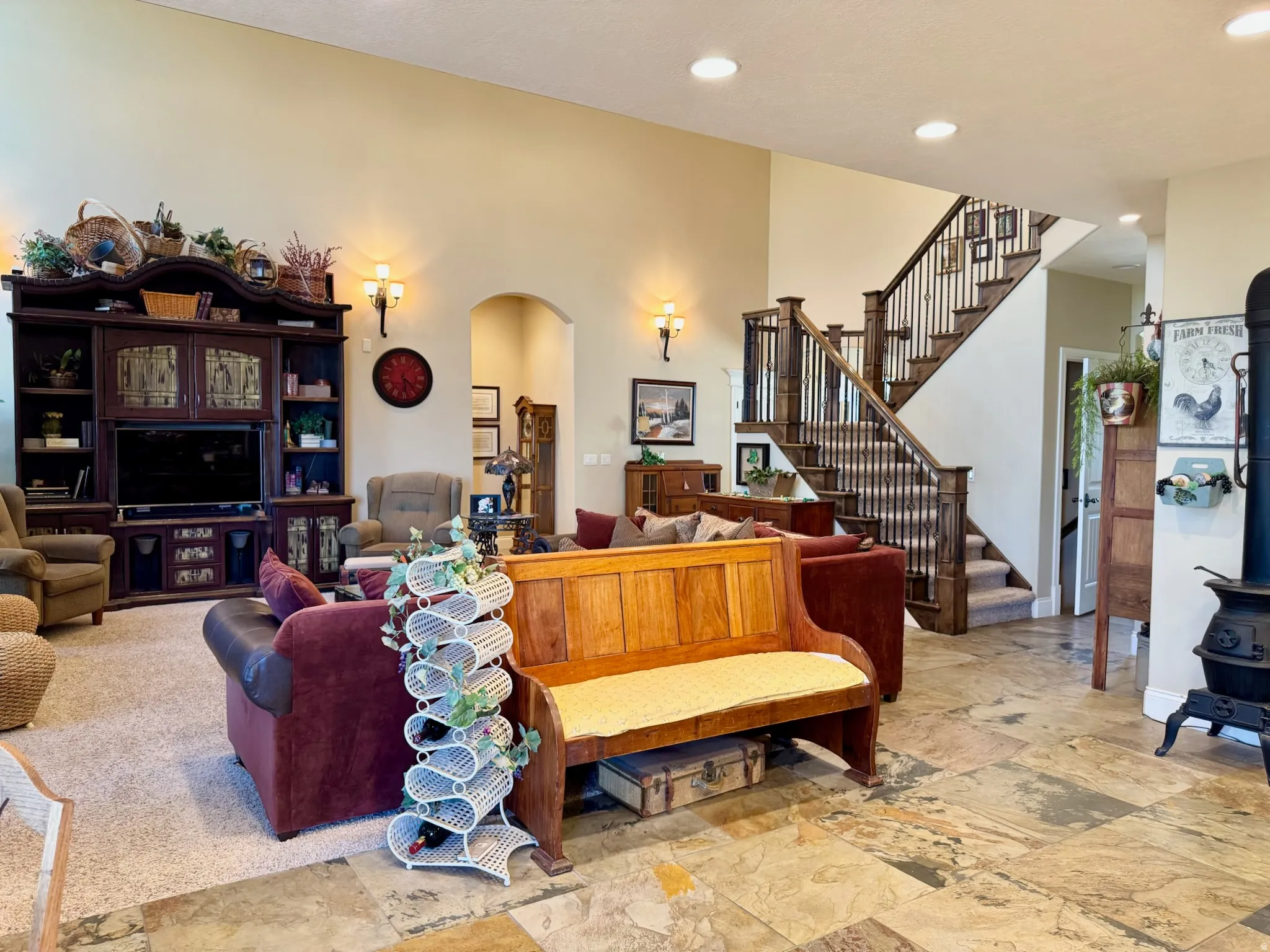Living area with arched walkways, recessed lighting, and light stone finish floors