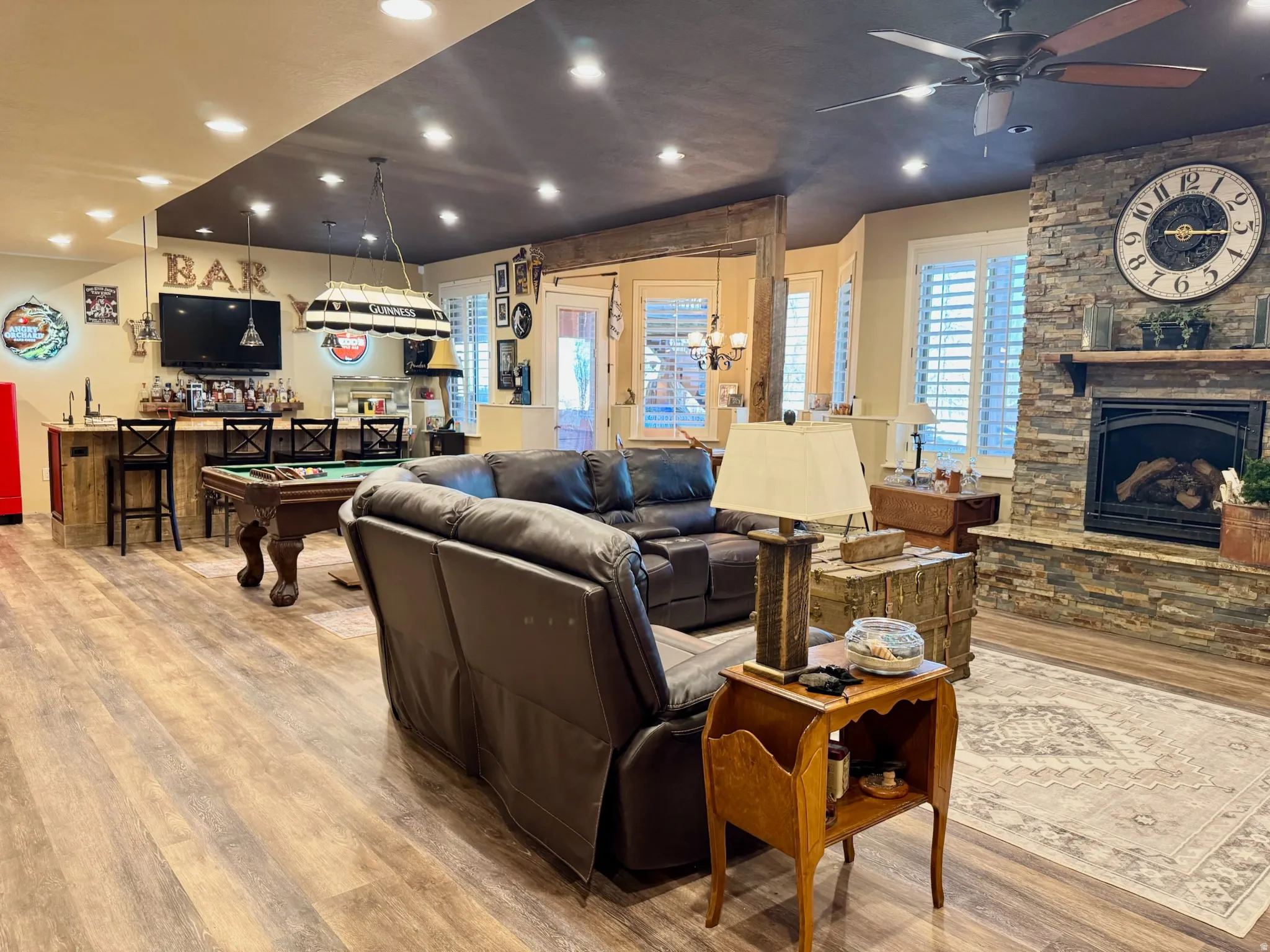 Living room with light wood-type flooring, a fireplace, bar area, recessed lighting, and billiards