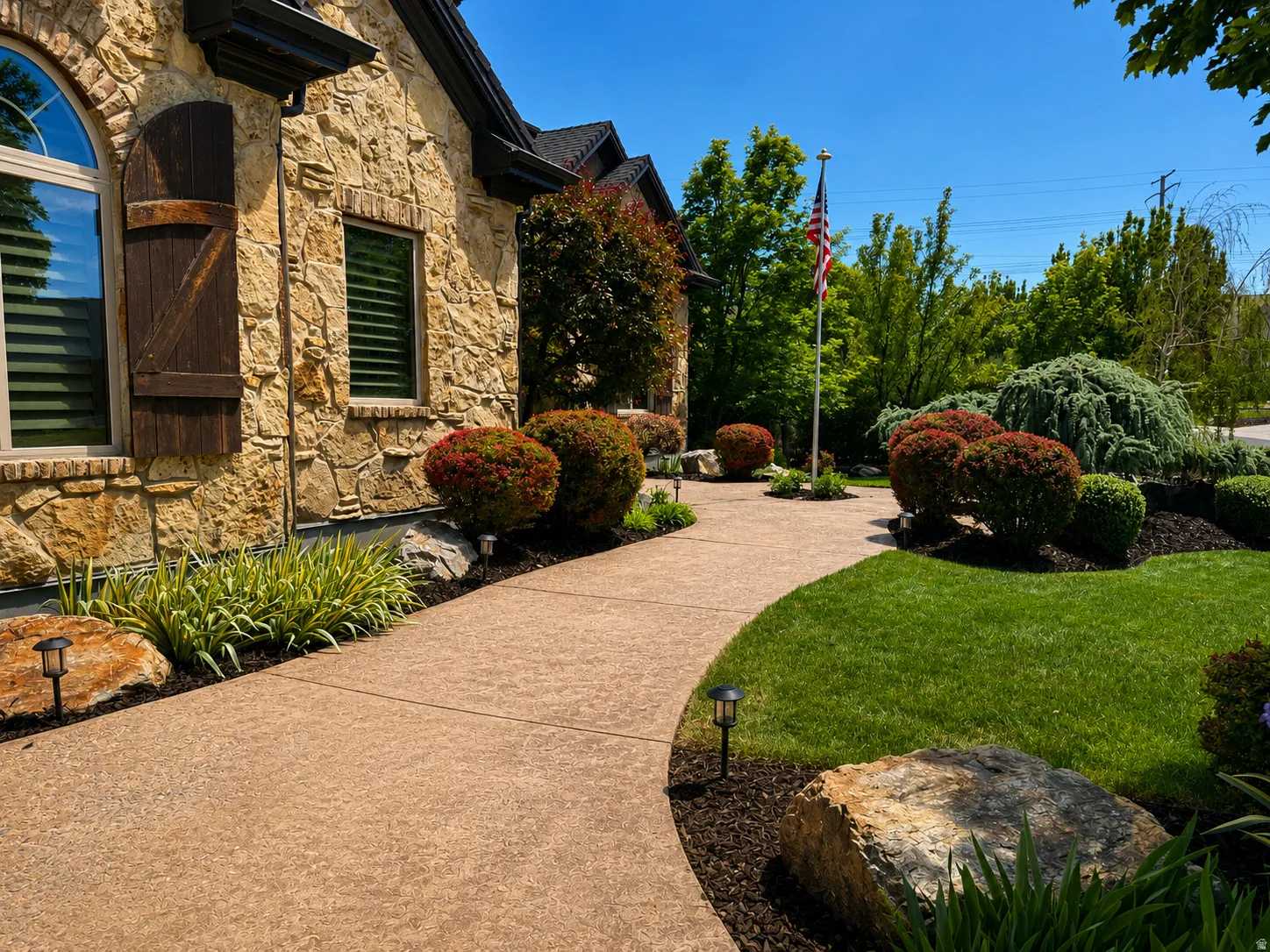 Stone facade exterior with an arched window and decorative wood shutters