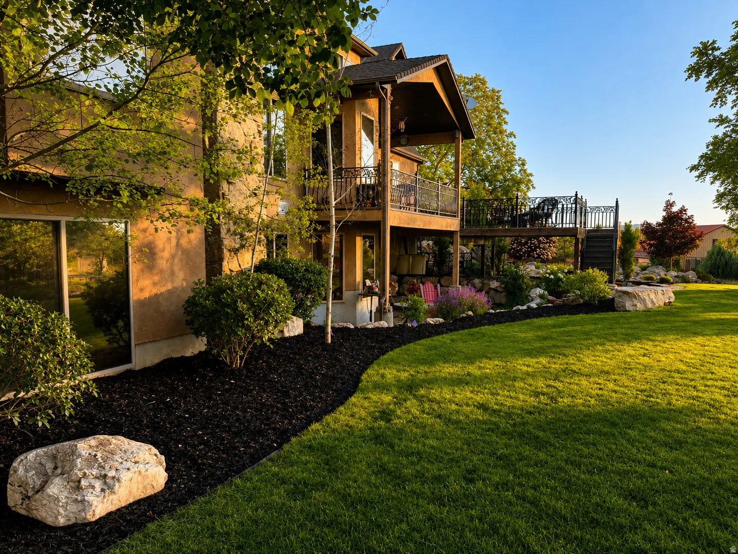 Expansive green lawn with a curved black mulch border