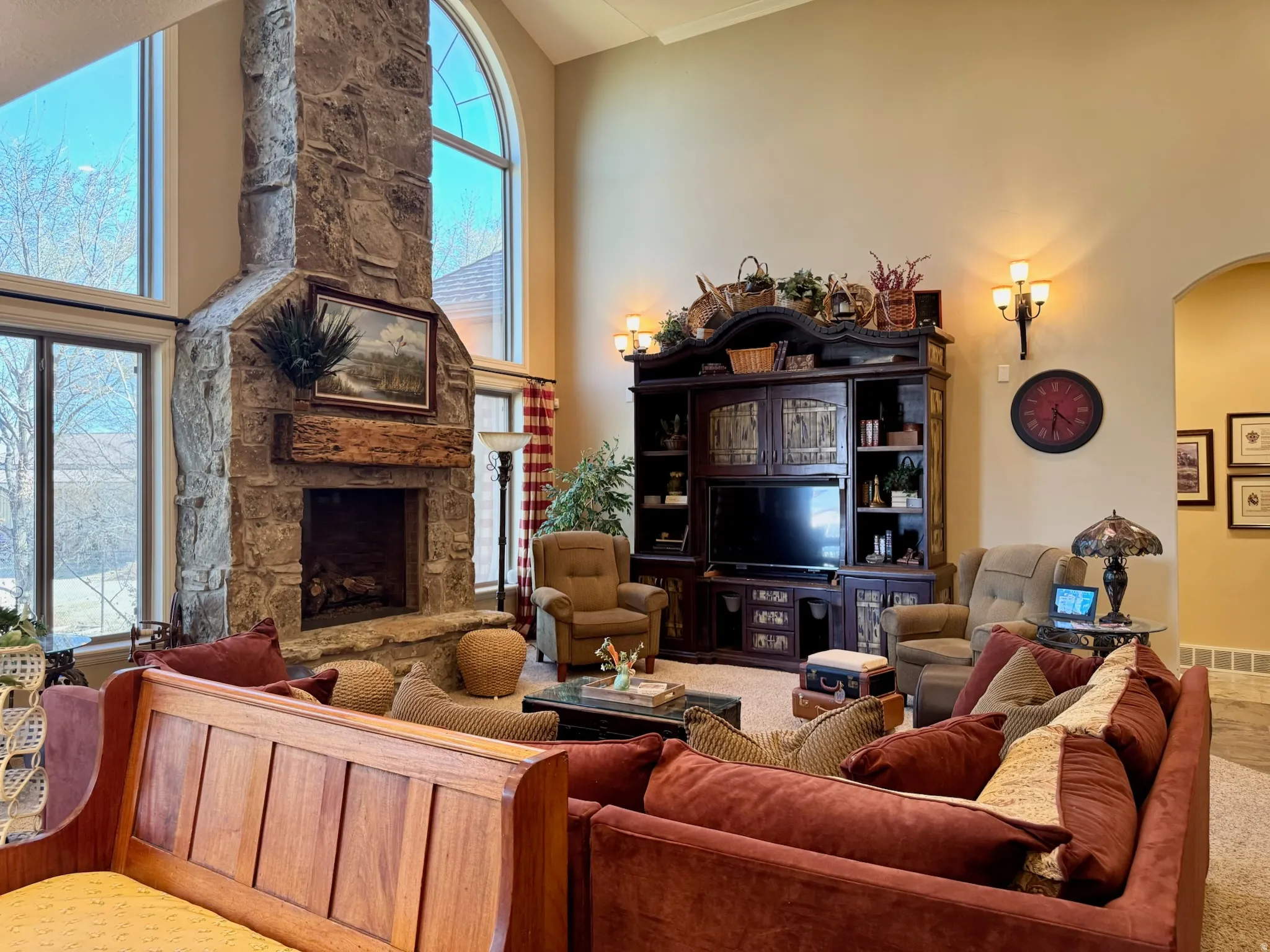 Carpeted living room featuring a fireplace, arched walkways, and lofted ceiling