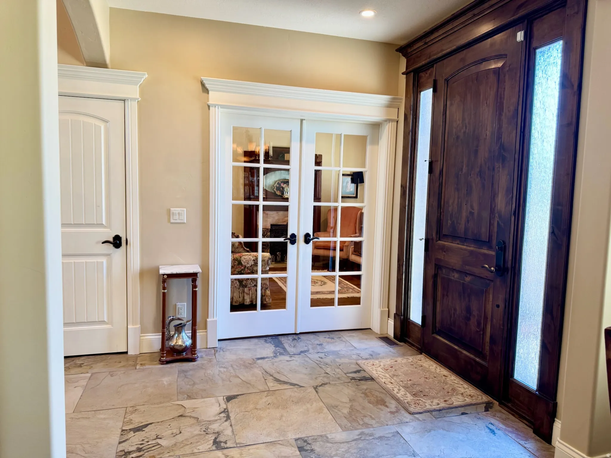 Entryway with french doors and light stone finish floors