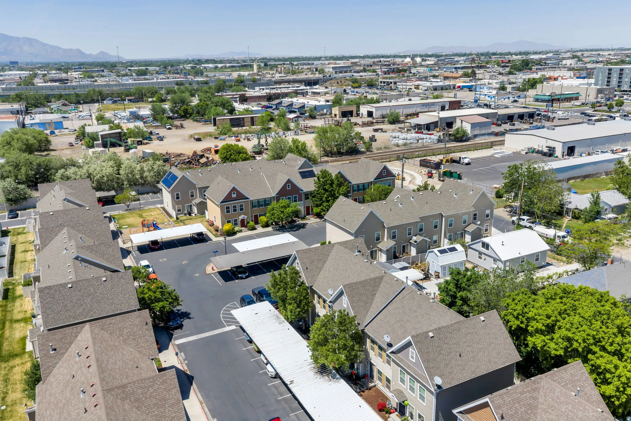 Aerial depiction of a multi-unit property featuring multiple buildings with gabled roofs and neutral siding