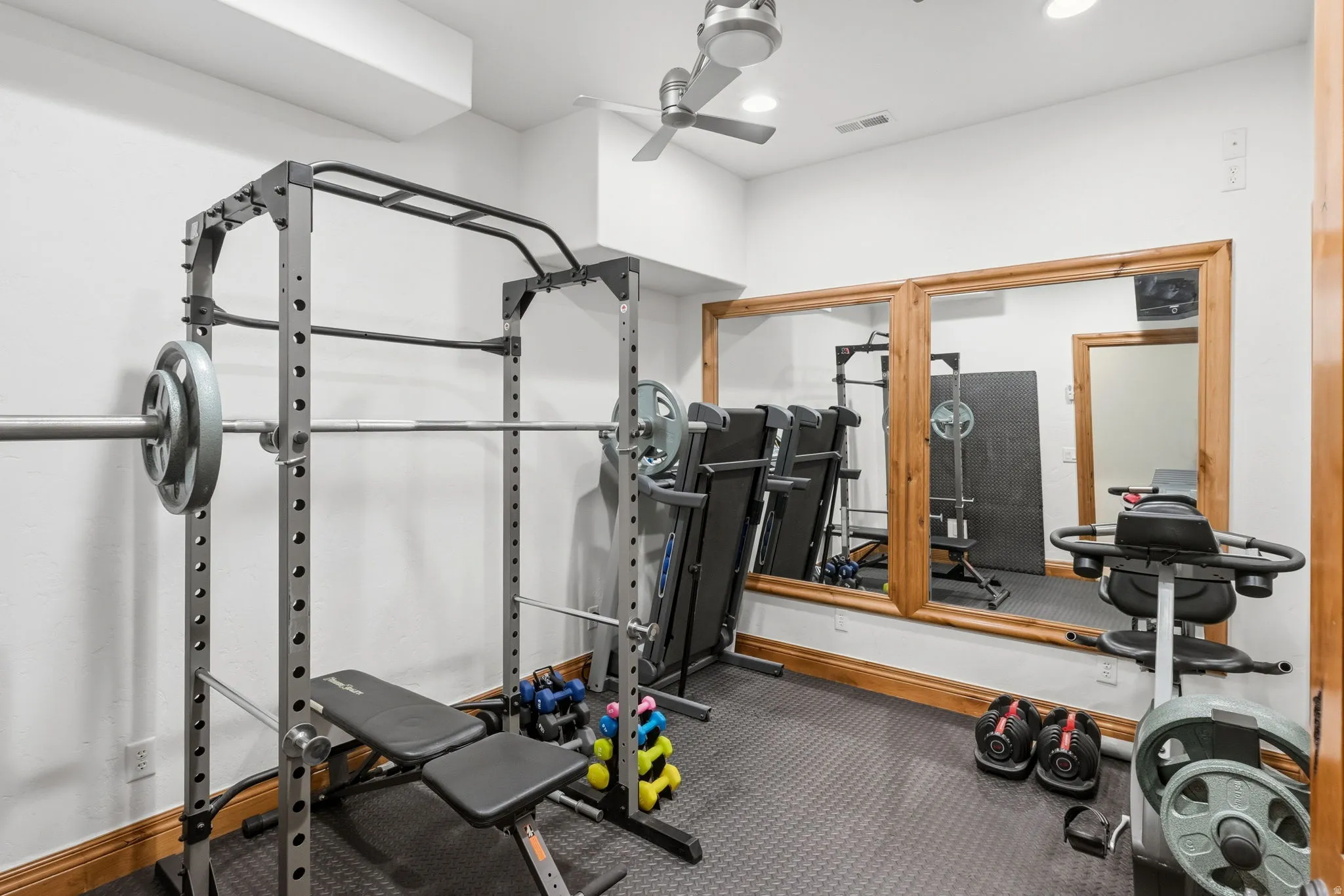 Workout room with a ceiling fan, rubber floors, and recessed lighting
