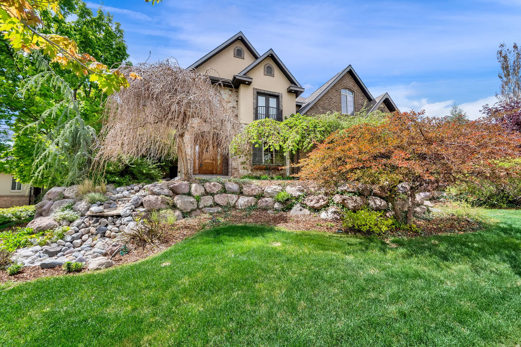 View of front facade featuring stucco siding and a front lawn