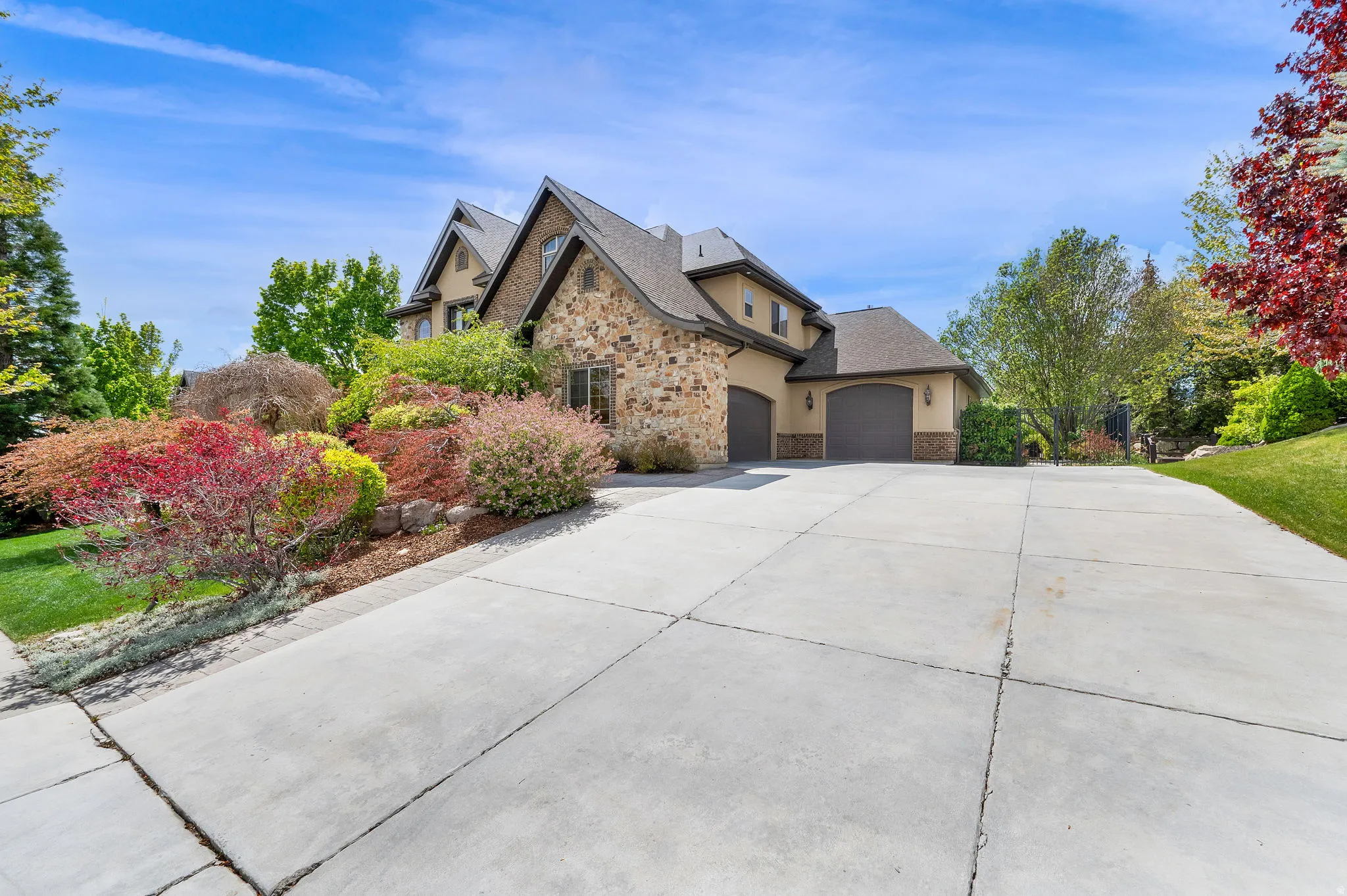 Craftsman-style house with stone siding, stucco siding, driveway, and an attached garage