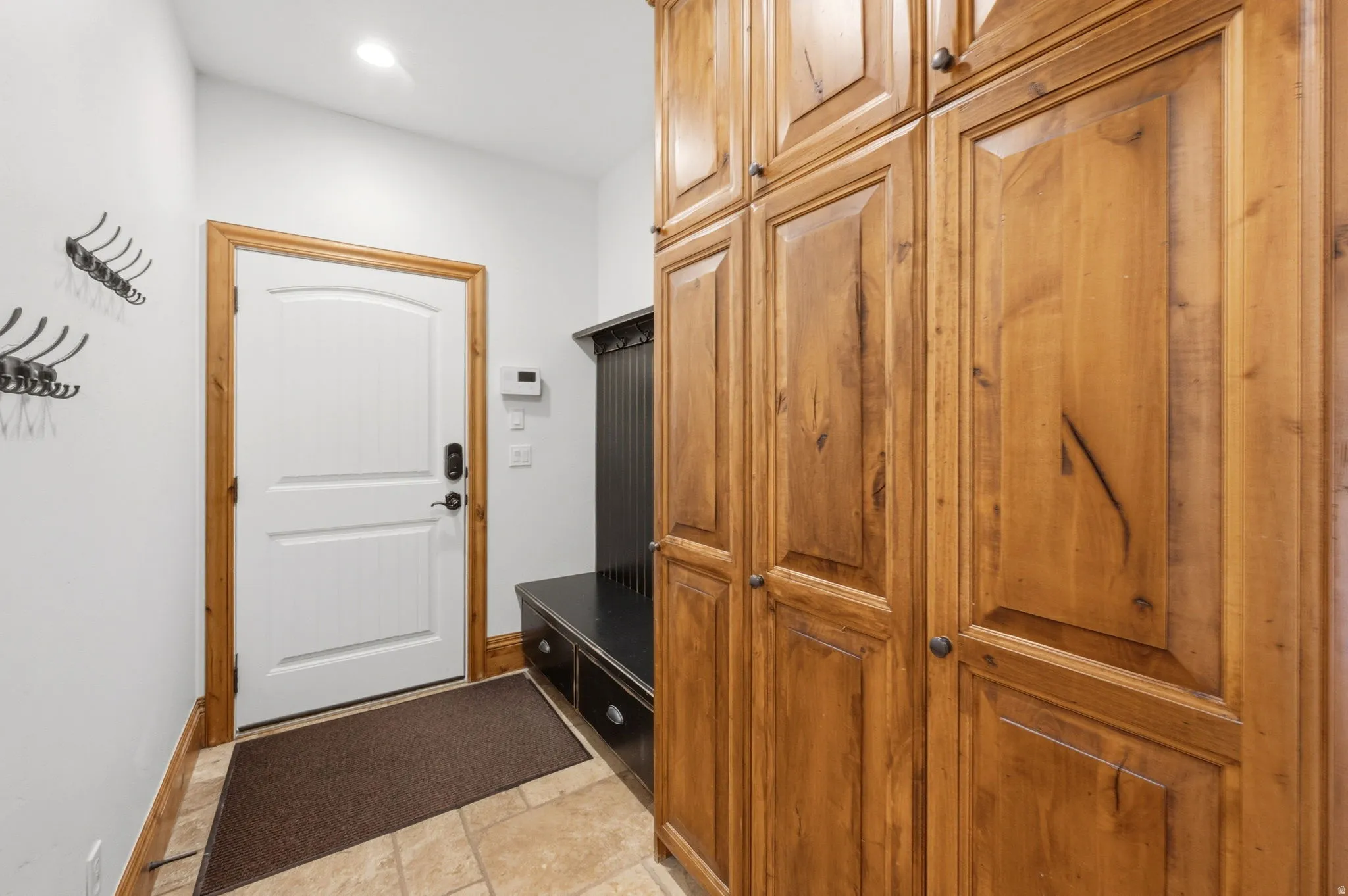 Mudroom featuring light stone finish flooring and recessed lighting