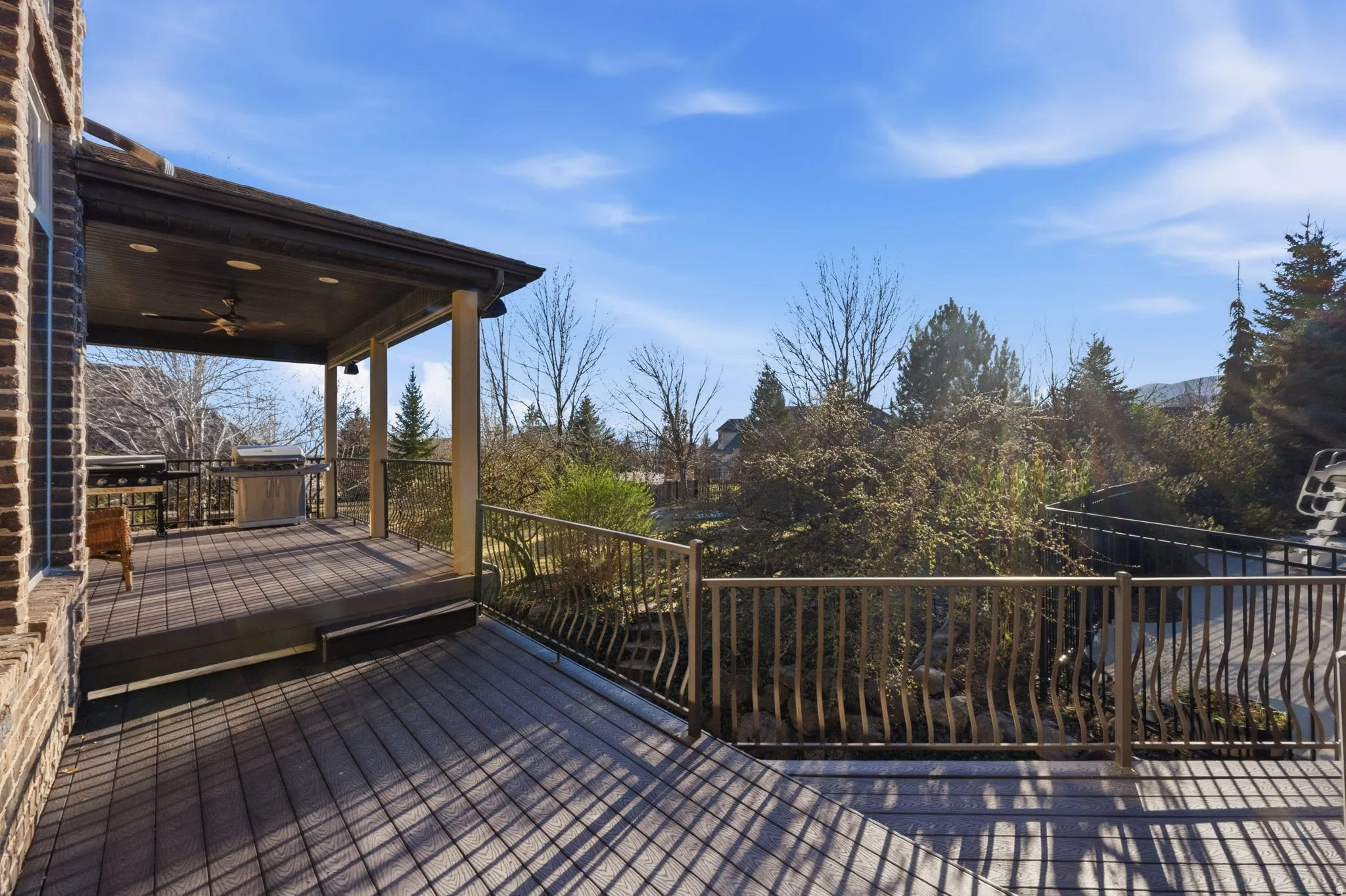 Wooden terrace featuring ceiling fan and grilling area