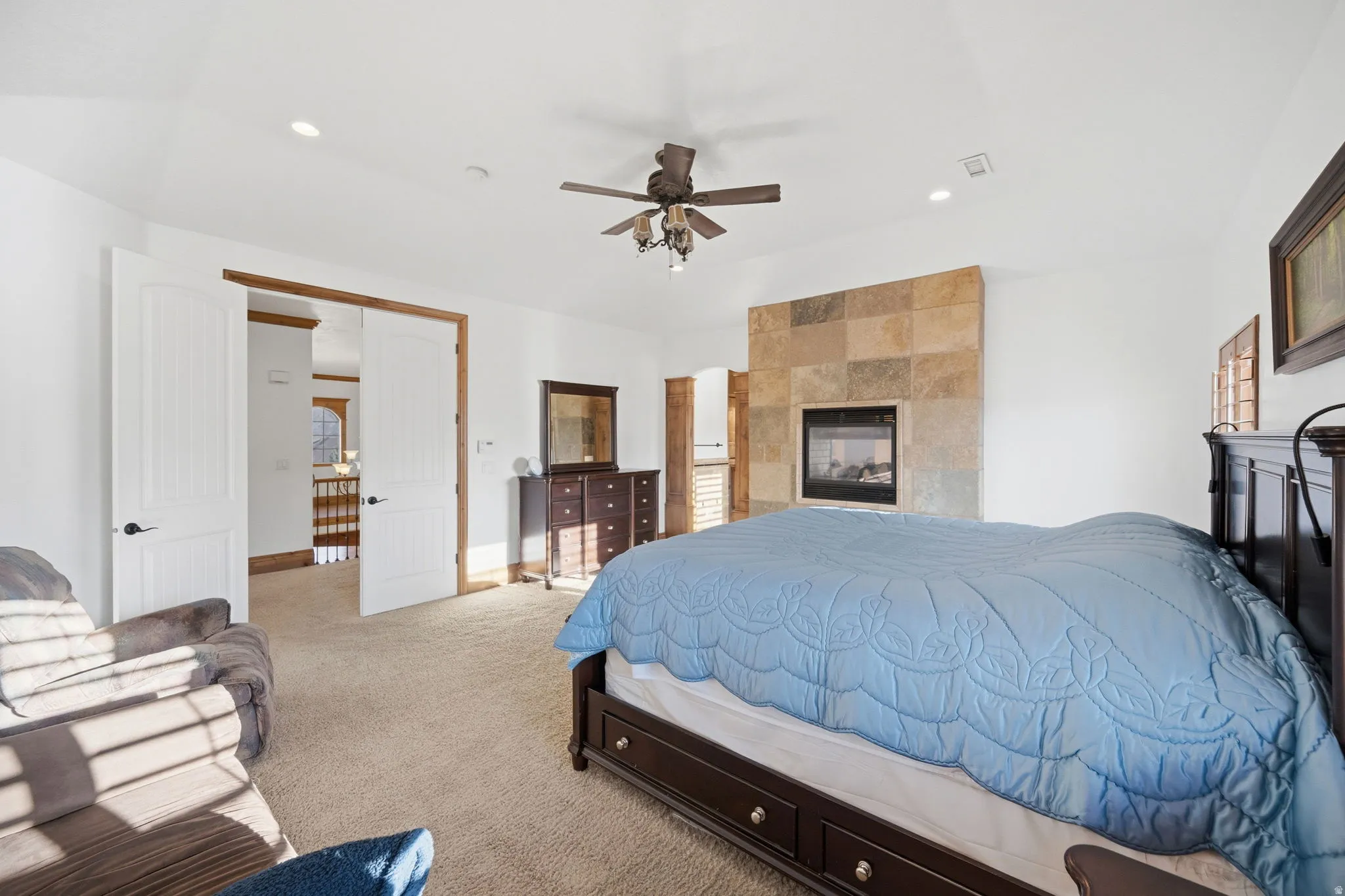 Bedroom with light colored carpet, recessed lighting, and a ceiling fan