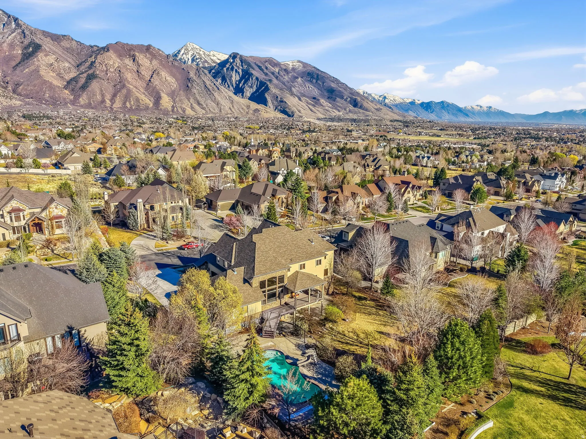 Aerial perspective of suburban area with mountains and a pool