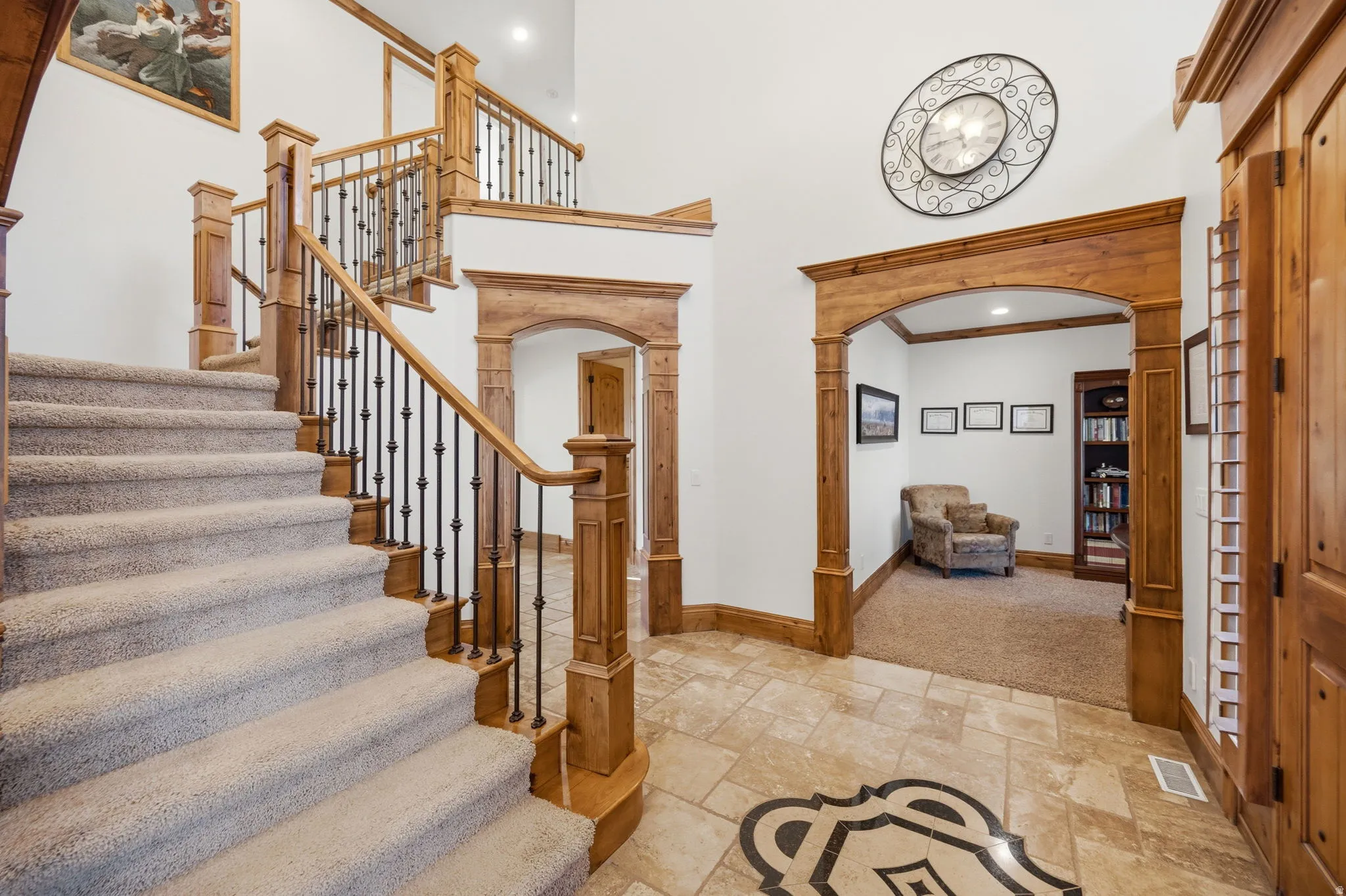 Entryway with arched walkways, stone tile flooring, a high ceiling, recessed lighting, and ornate columns
