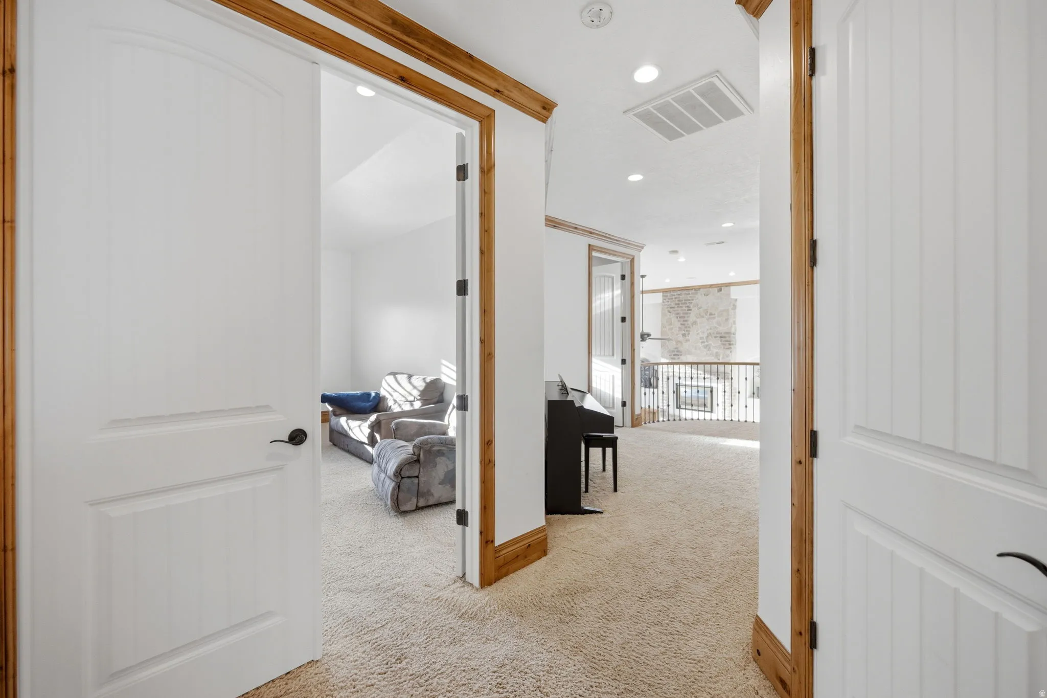 Hall with light colored carpet and recessed lighting
