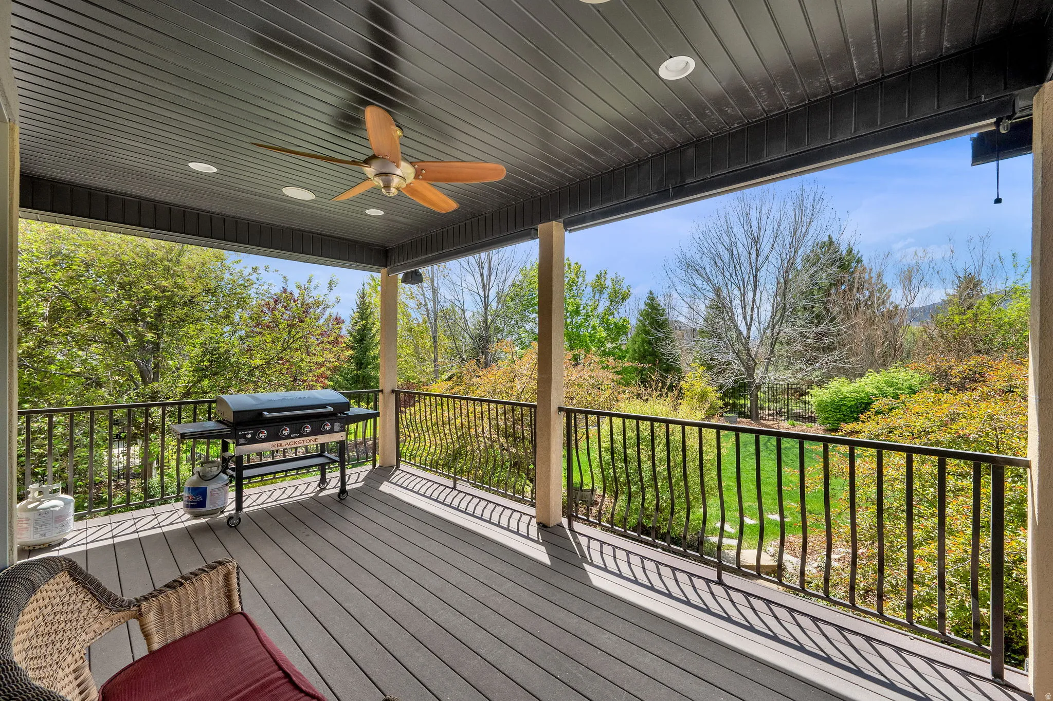 Deck with a ceiling fan and area for grilling