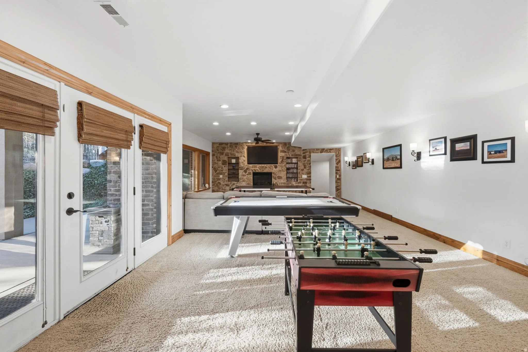 Game room featuring a large fireplace, recessed lighting, light carpet, and ceiling fan