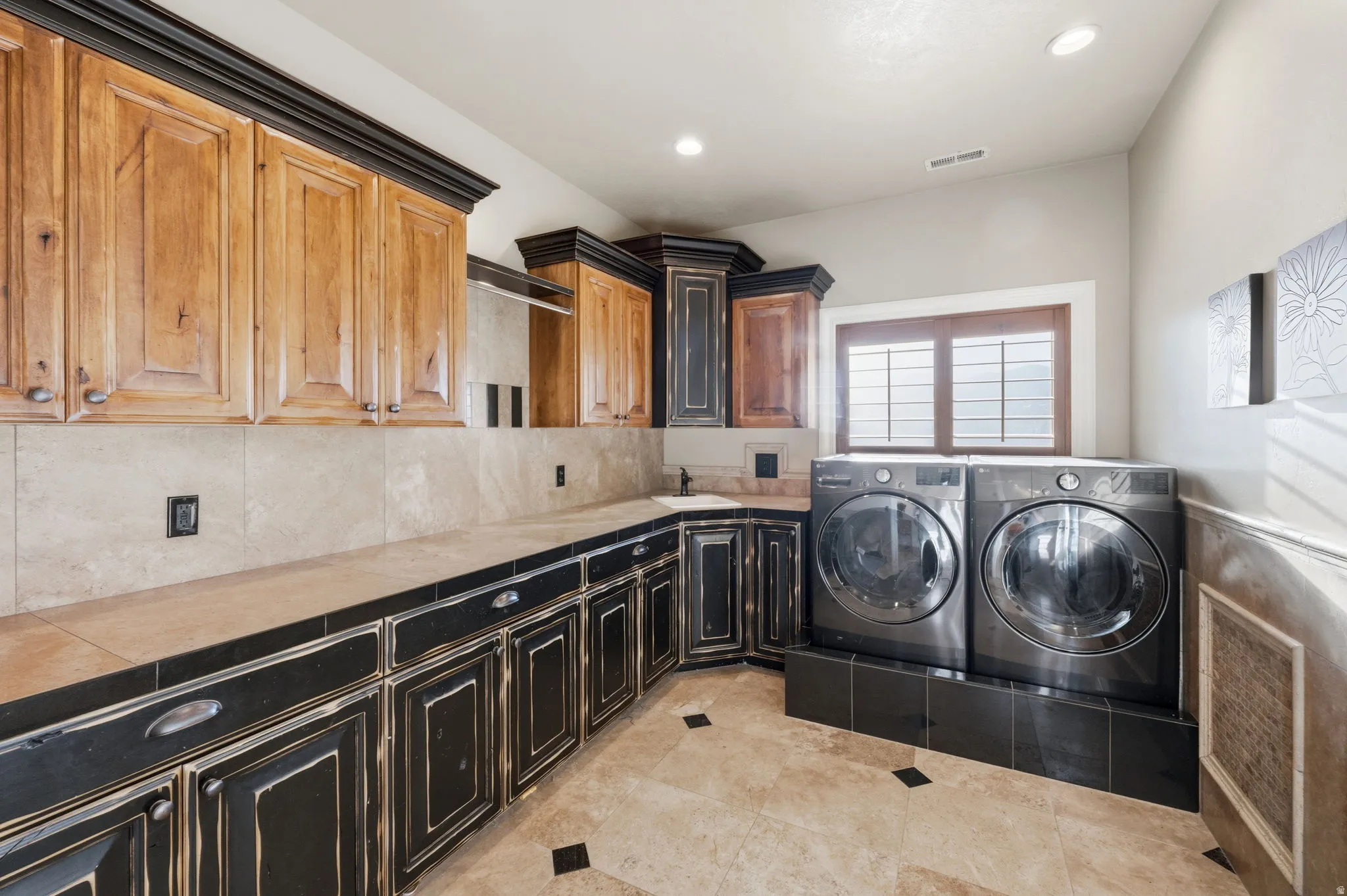 Laundry area with cabinet space, independent washer and dryer, recessed lighting, and light tile patterned floors