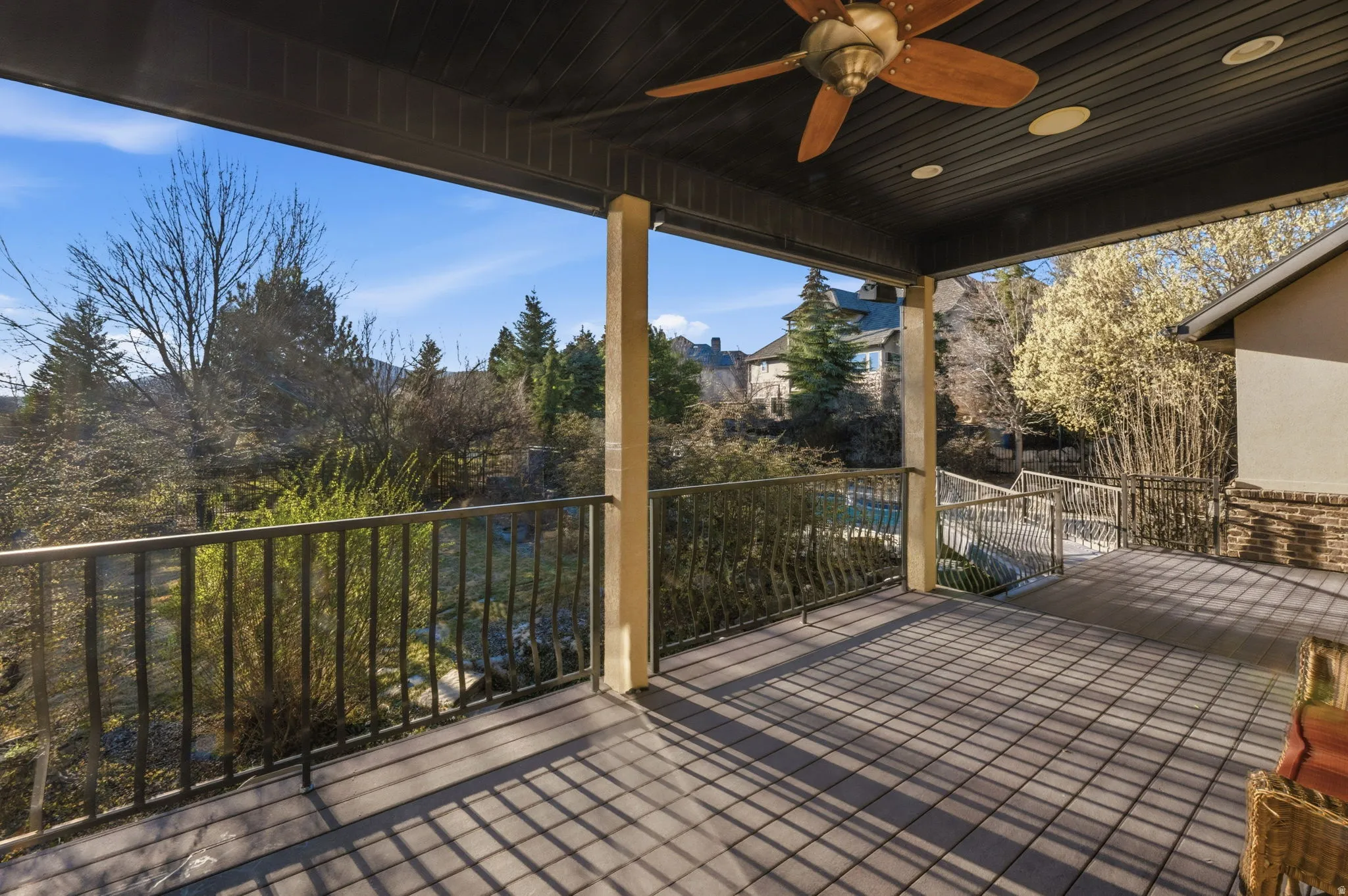 Wooden terrace with ceiling fan and a patio