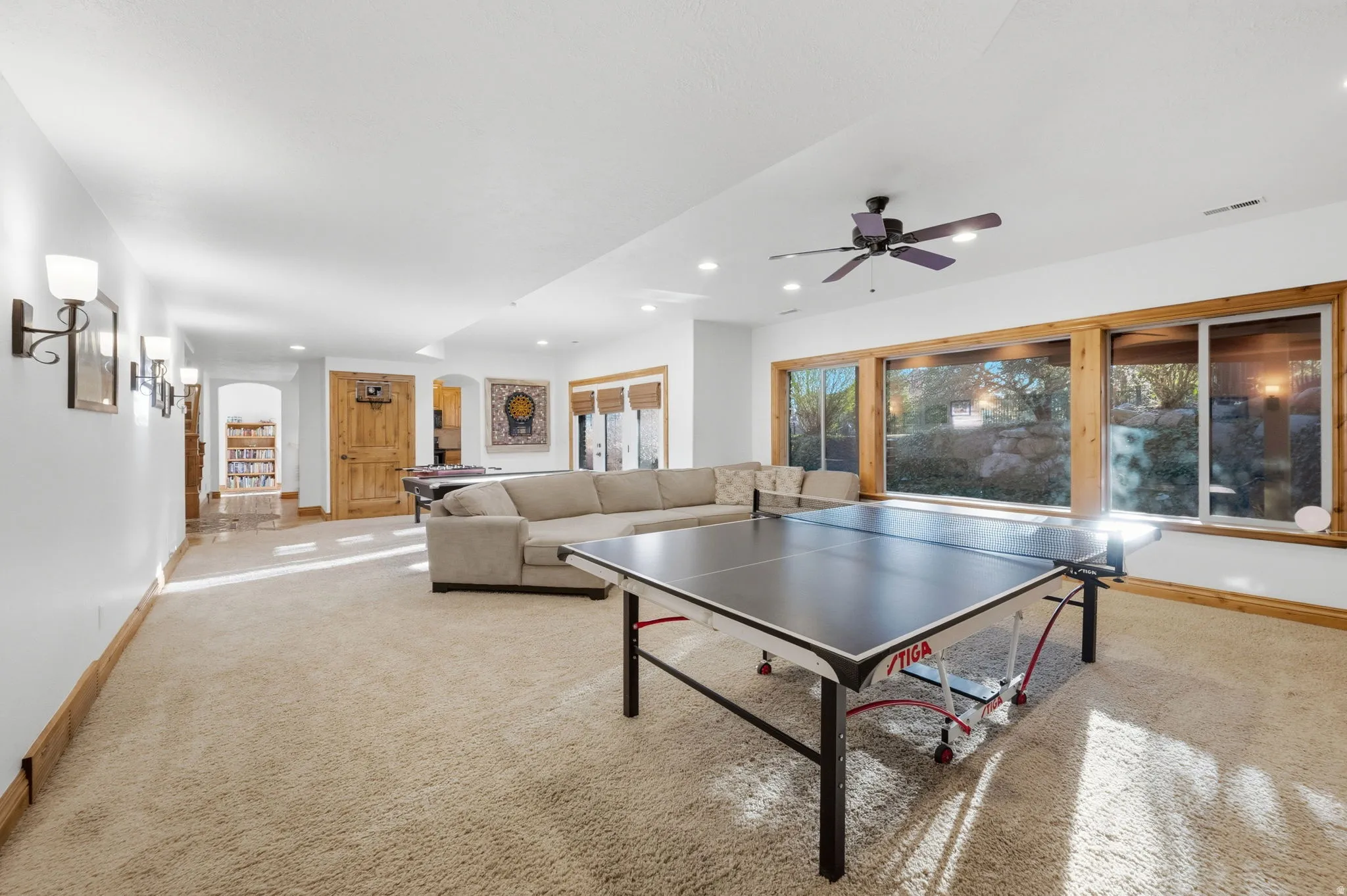 Game room with light colored carpet, arched walkways, ceiling fan, and recessed lighting