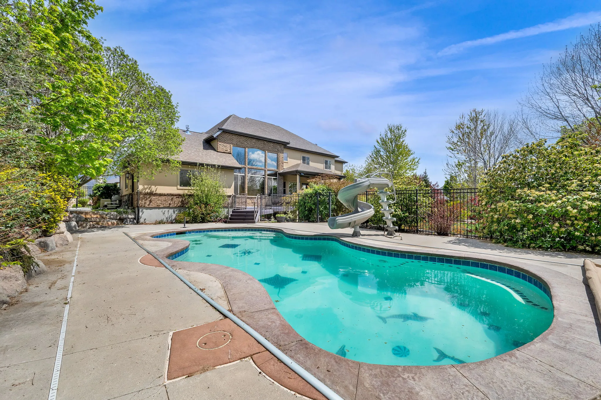 View of swimming pool with a water slide and patio surround