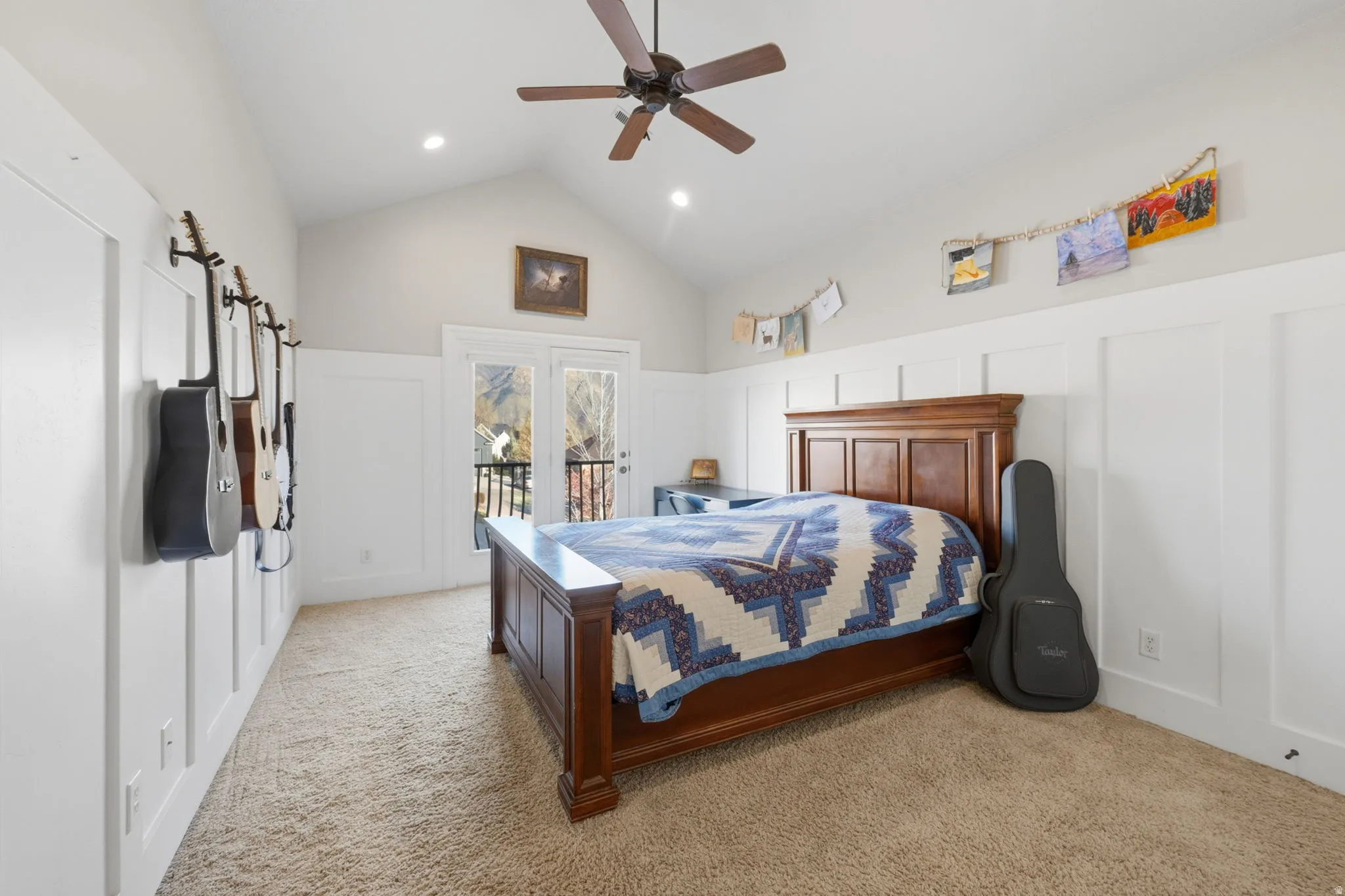 Bedroom featuring a decorative wall, access to exterior, lofted ceiling, light carpet, and ceiling fan