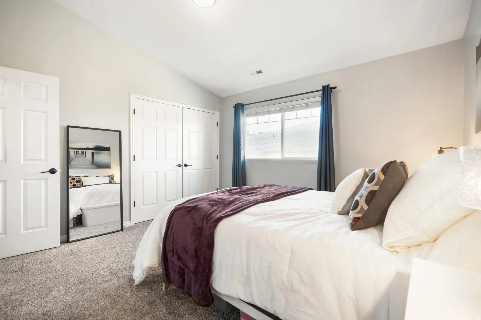Bedroom with vaulted ceiling, carpet, and a closet