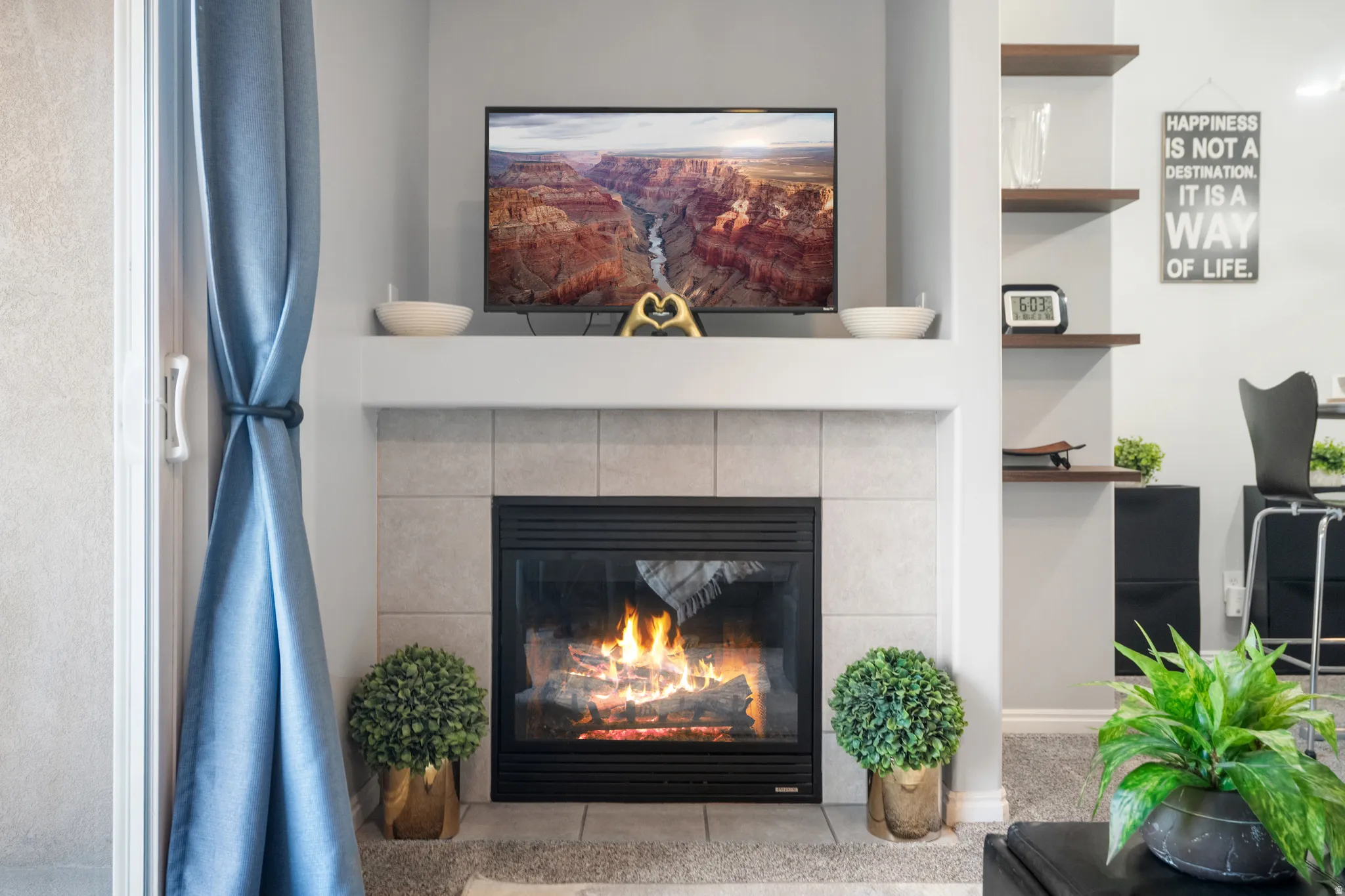 Detailed view of a tiled fireplace and carpet floors