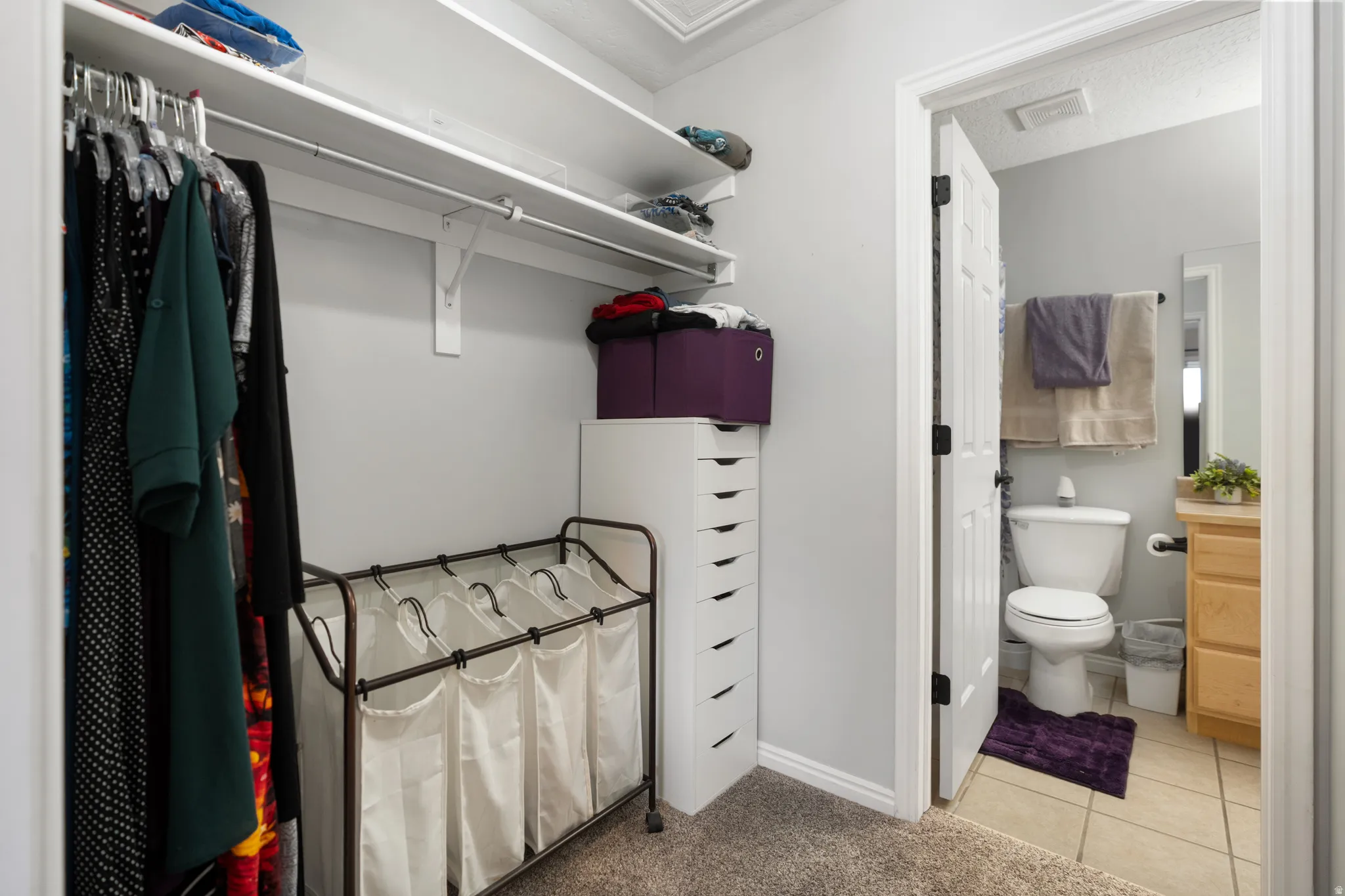 Walk in closet featuring light colored carpet and light tile patterned flooring