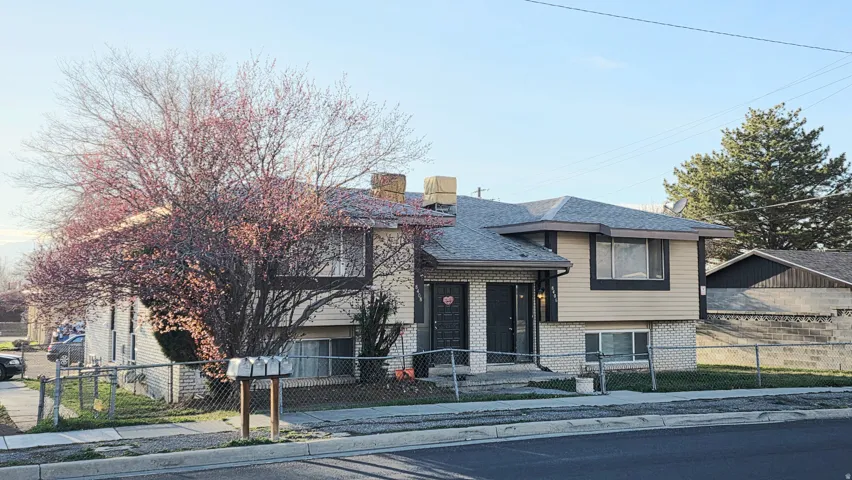 View of front of house with brick siding, a fenced front yard, and a chimney