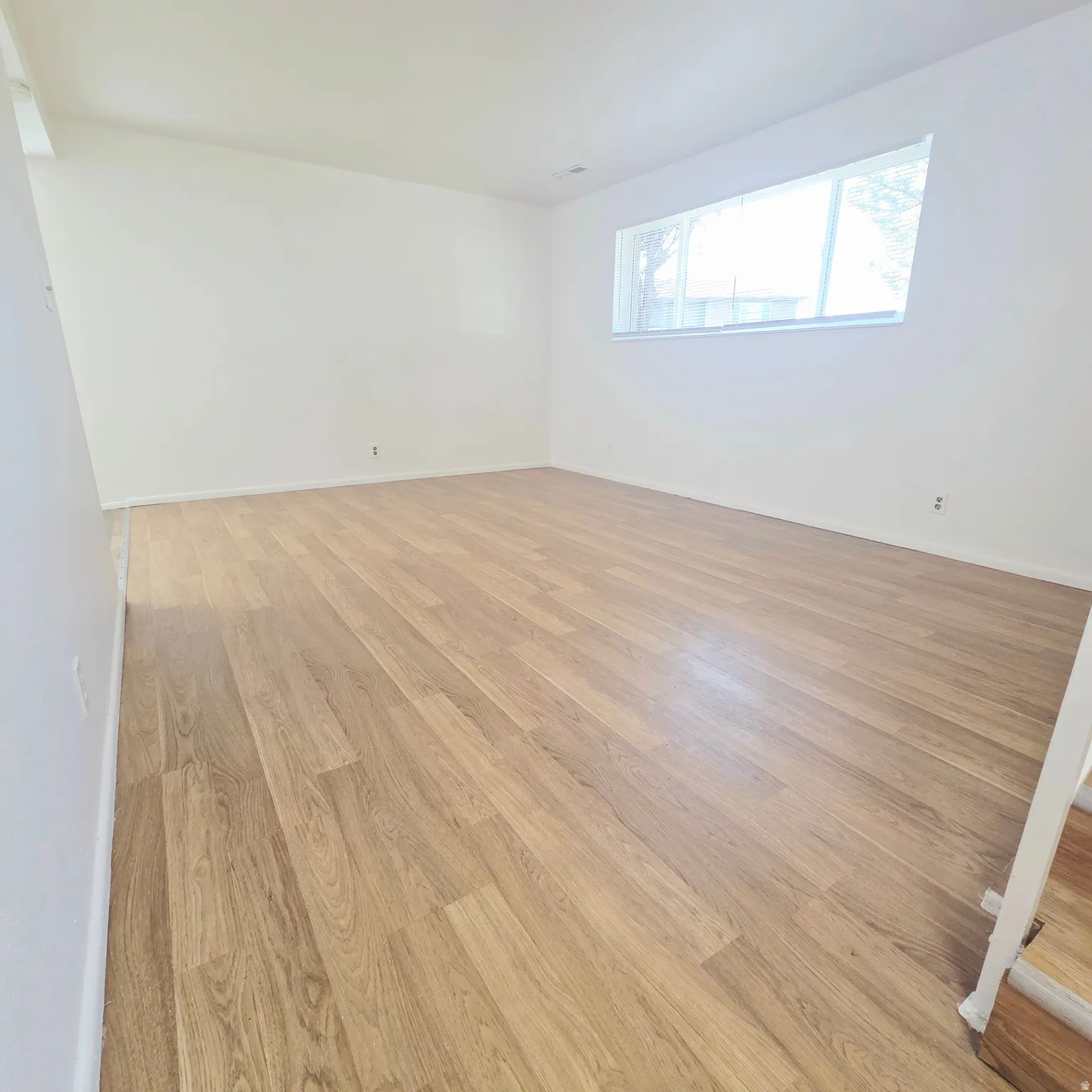 Empty room with light wood-style flooring and baseboards