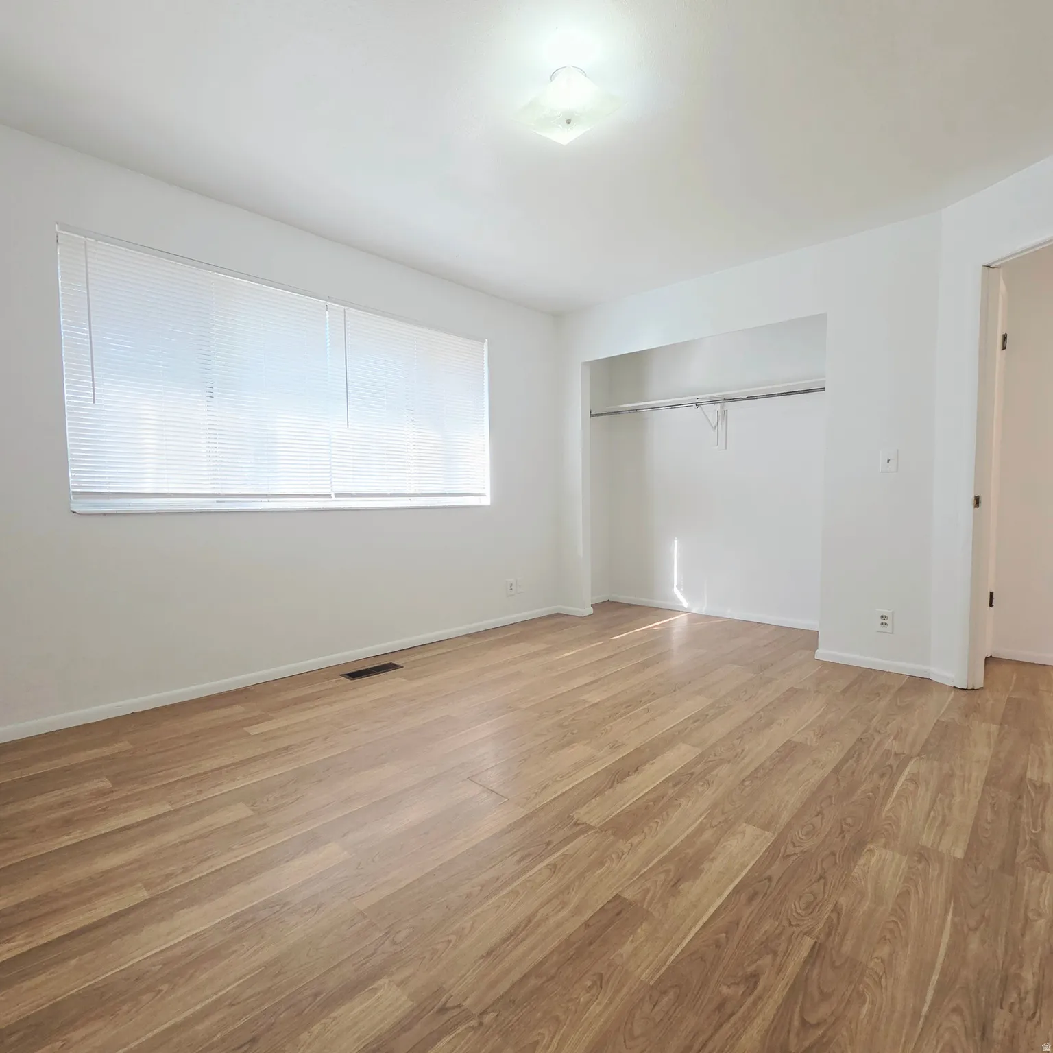 Unfurnished bedroom with light wood-style flooring and a closet