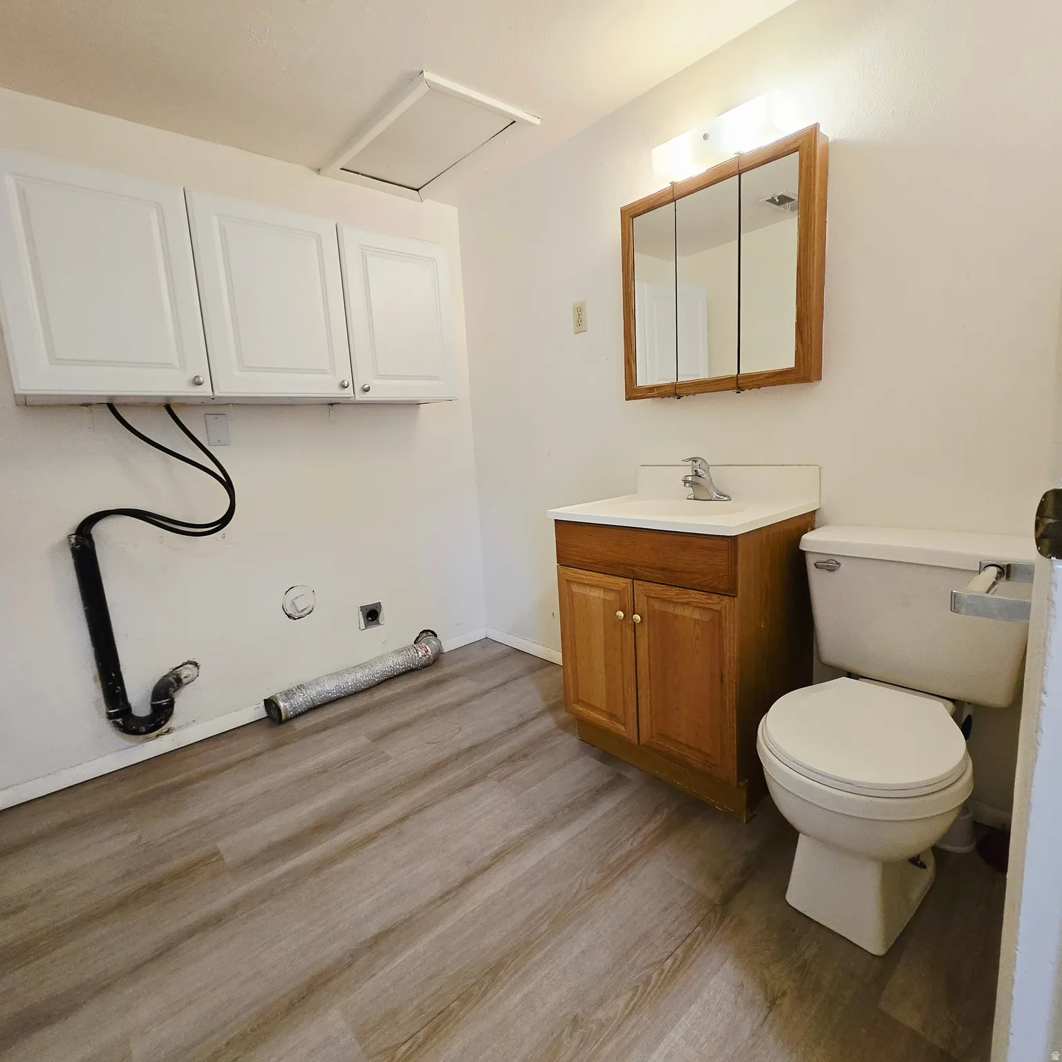 Half bathroom featuring vanity and wood finished floors