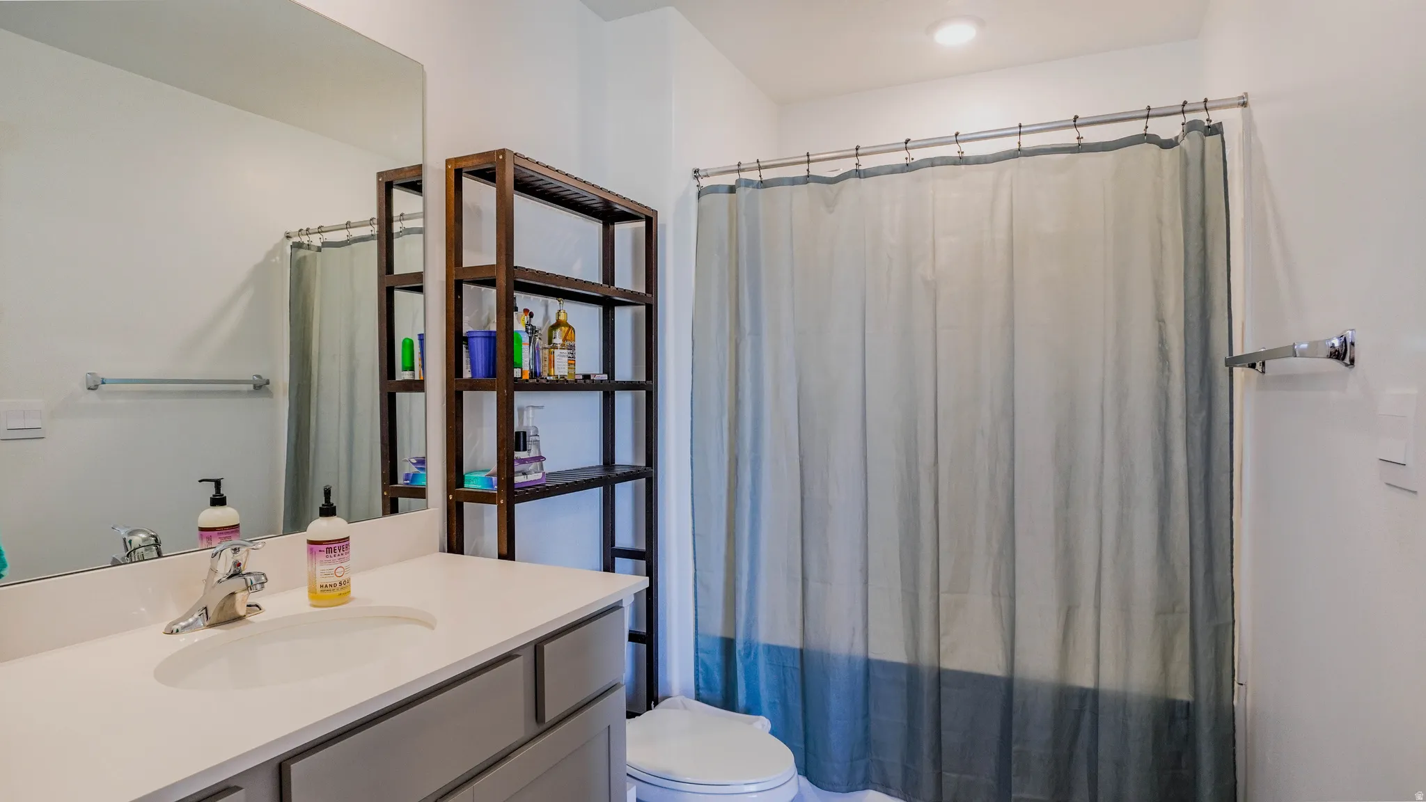 Full bath featuring vanity and curtained shower