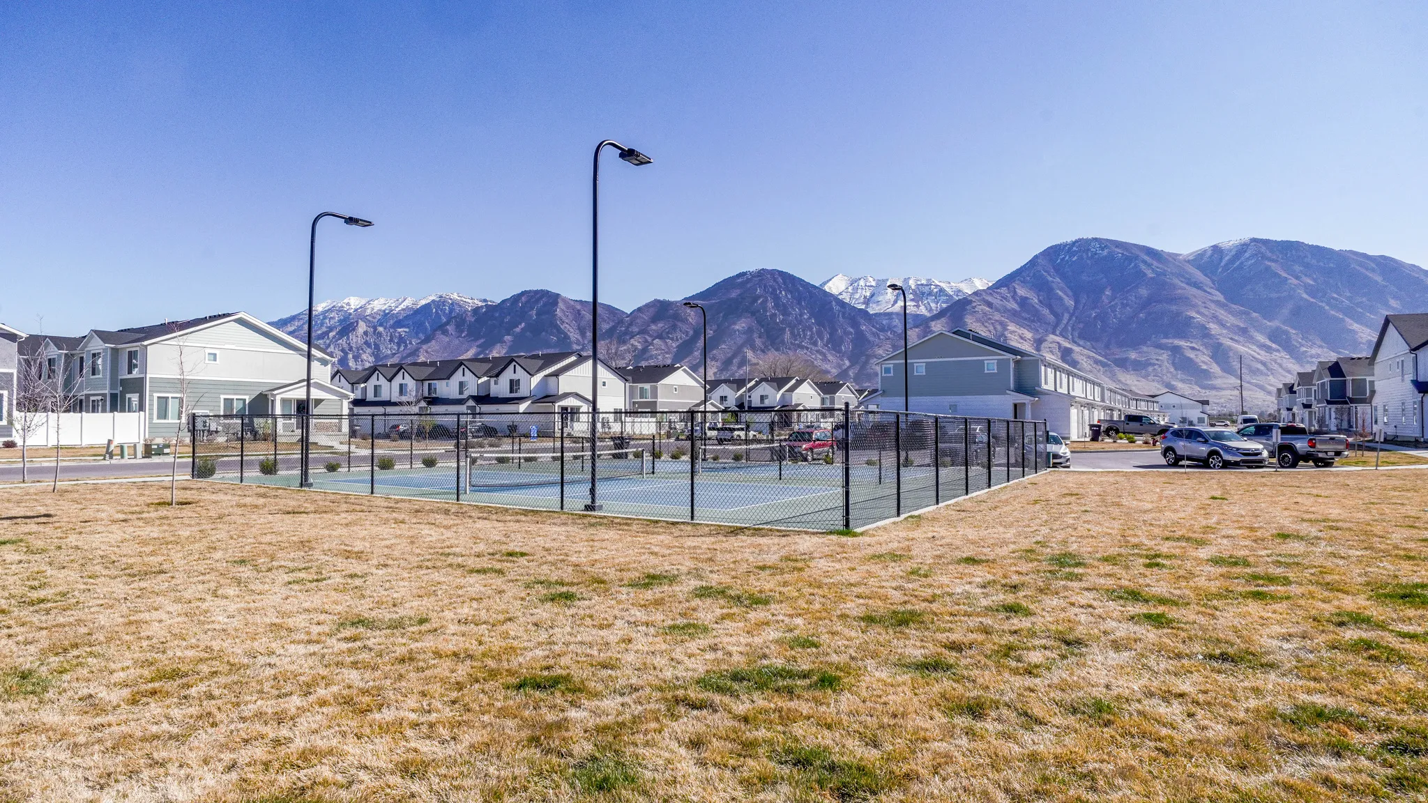 View of tennis court featuring a residential view and a mountain view