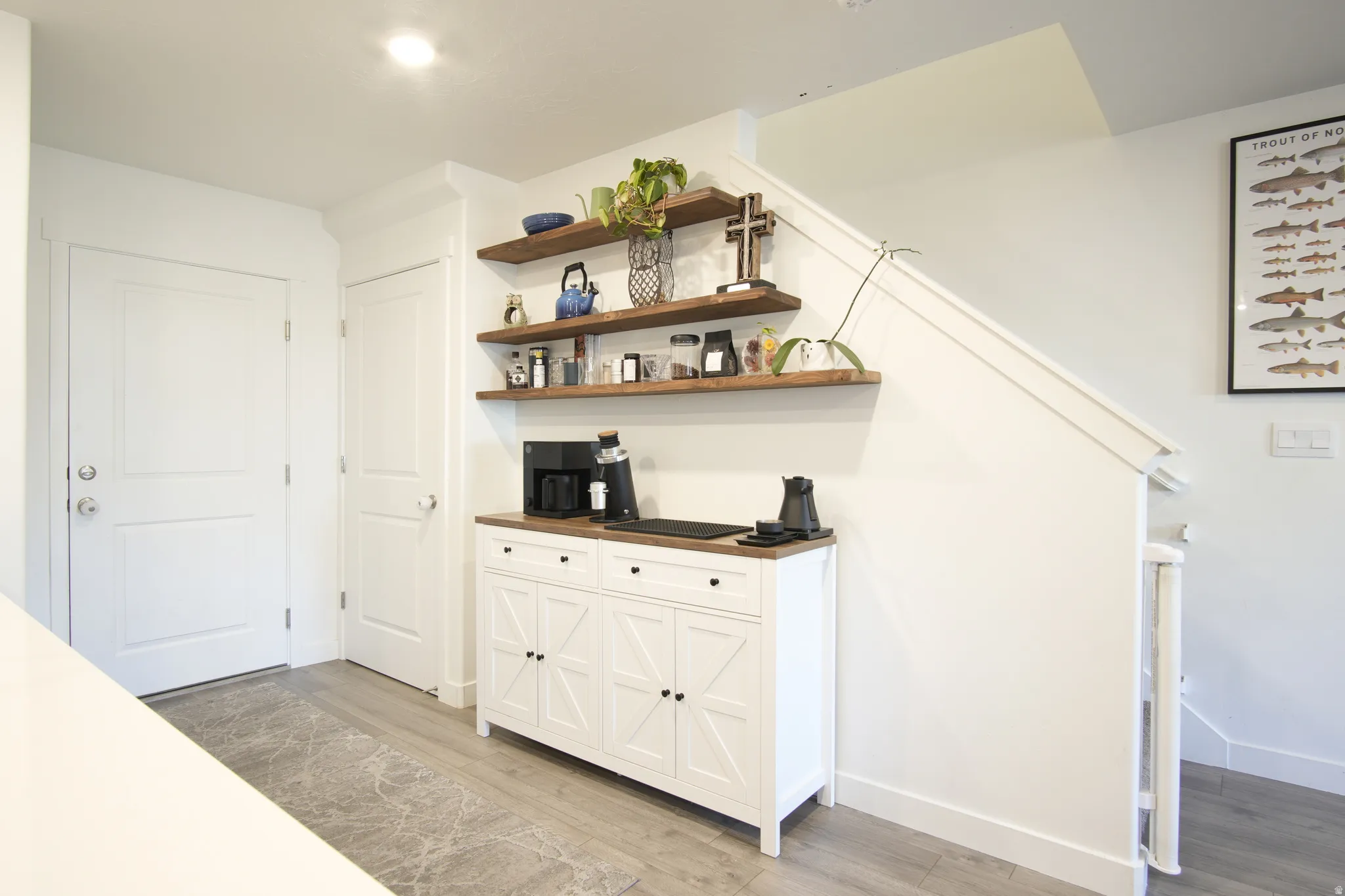 Interior space with light wood-type flooring, white cabinetry, wooden counters, and open shelves
