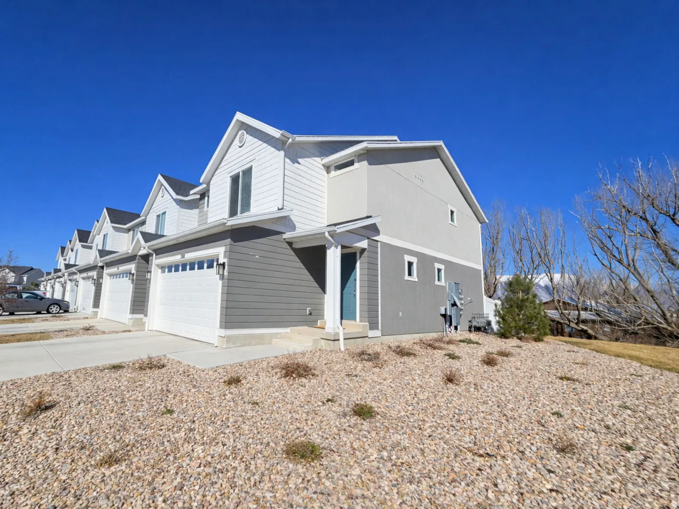 View of property exterior featuring a residential view, an attached garage, and driveway