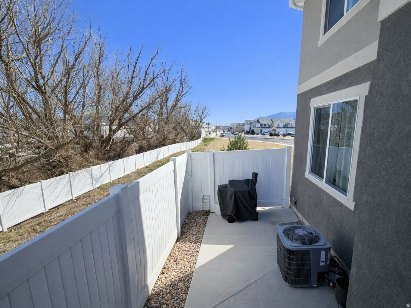 Fenced backyard featuring a grill, a residential view, a patio area, and a mountain view