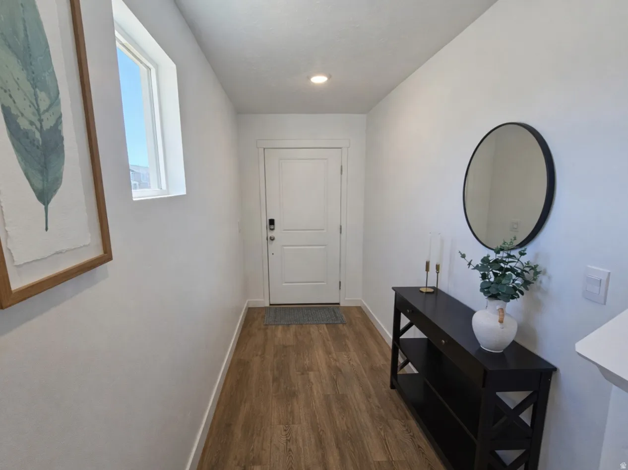 Corridor with dark wood-type flooring and baseboards