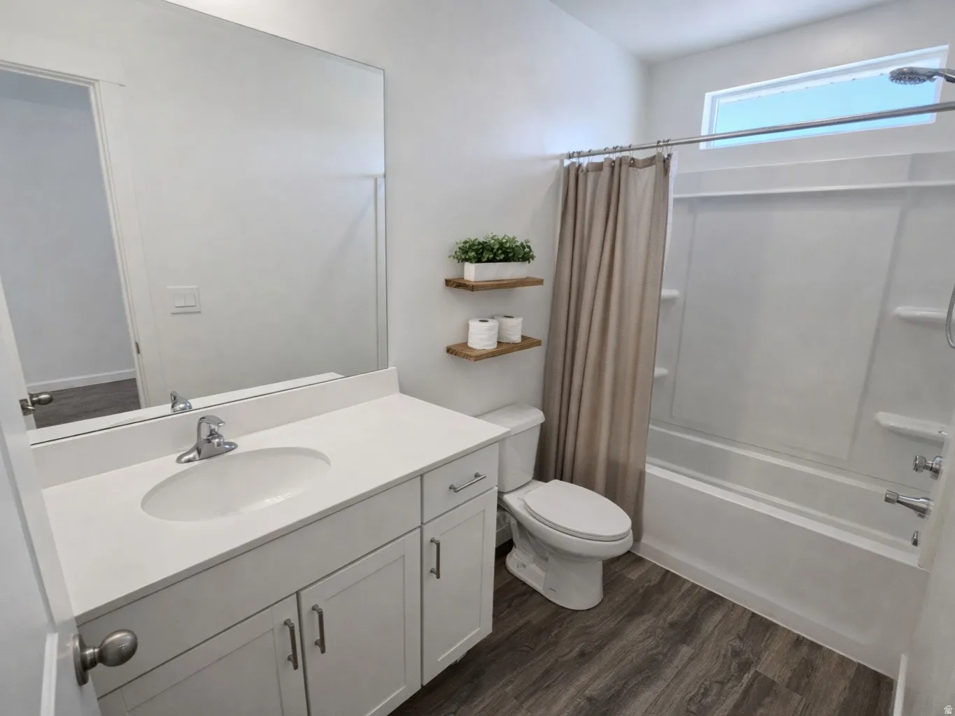 Bathroom featuring vanity, shower / tub combo, and dark wood-type flooring
