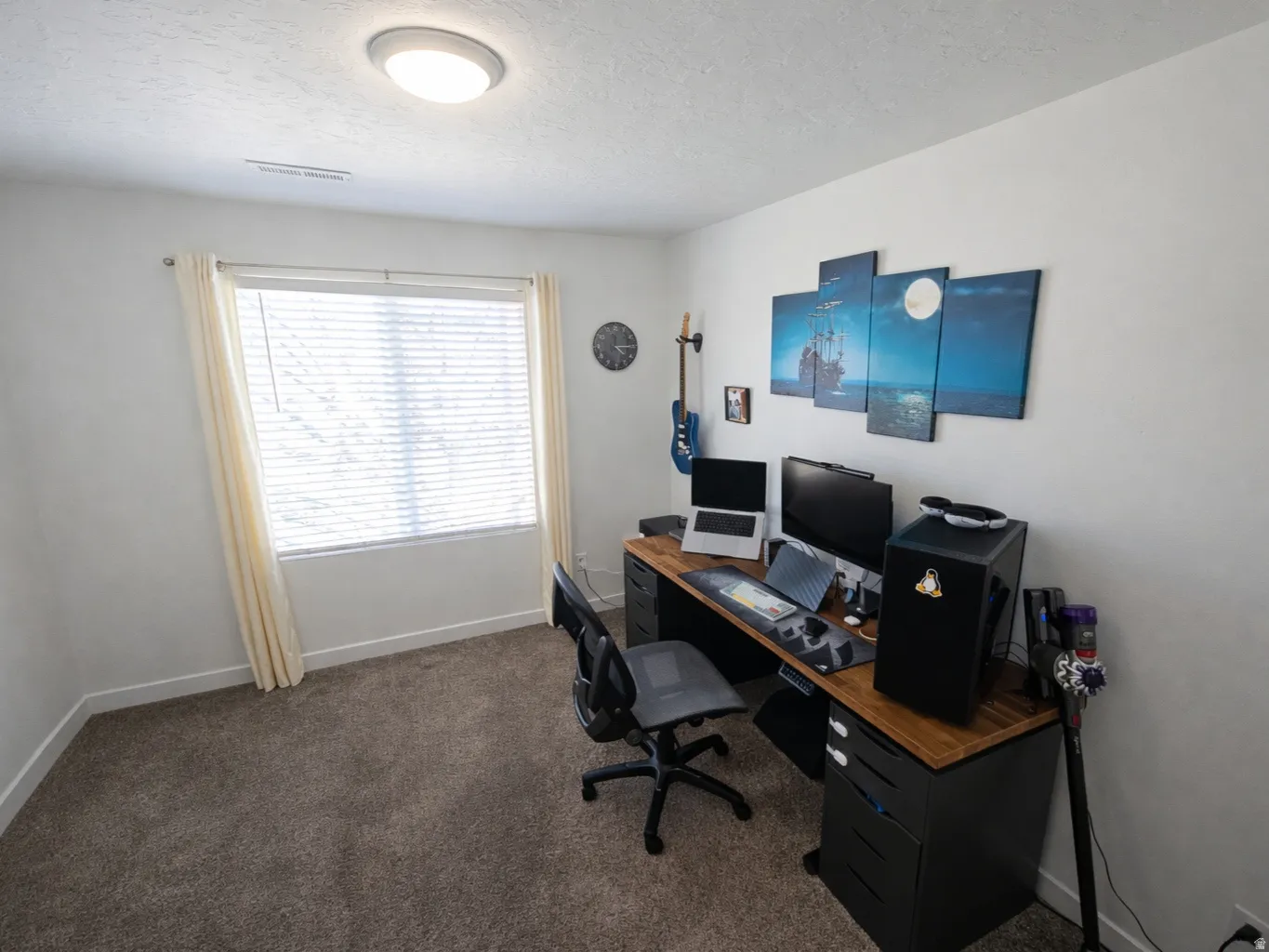 Office with dark carpet and a textured ceiling